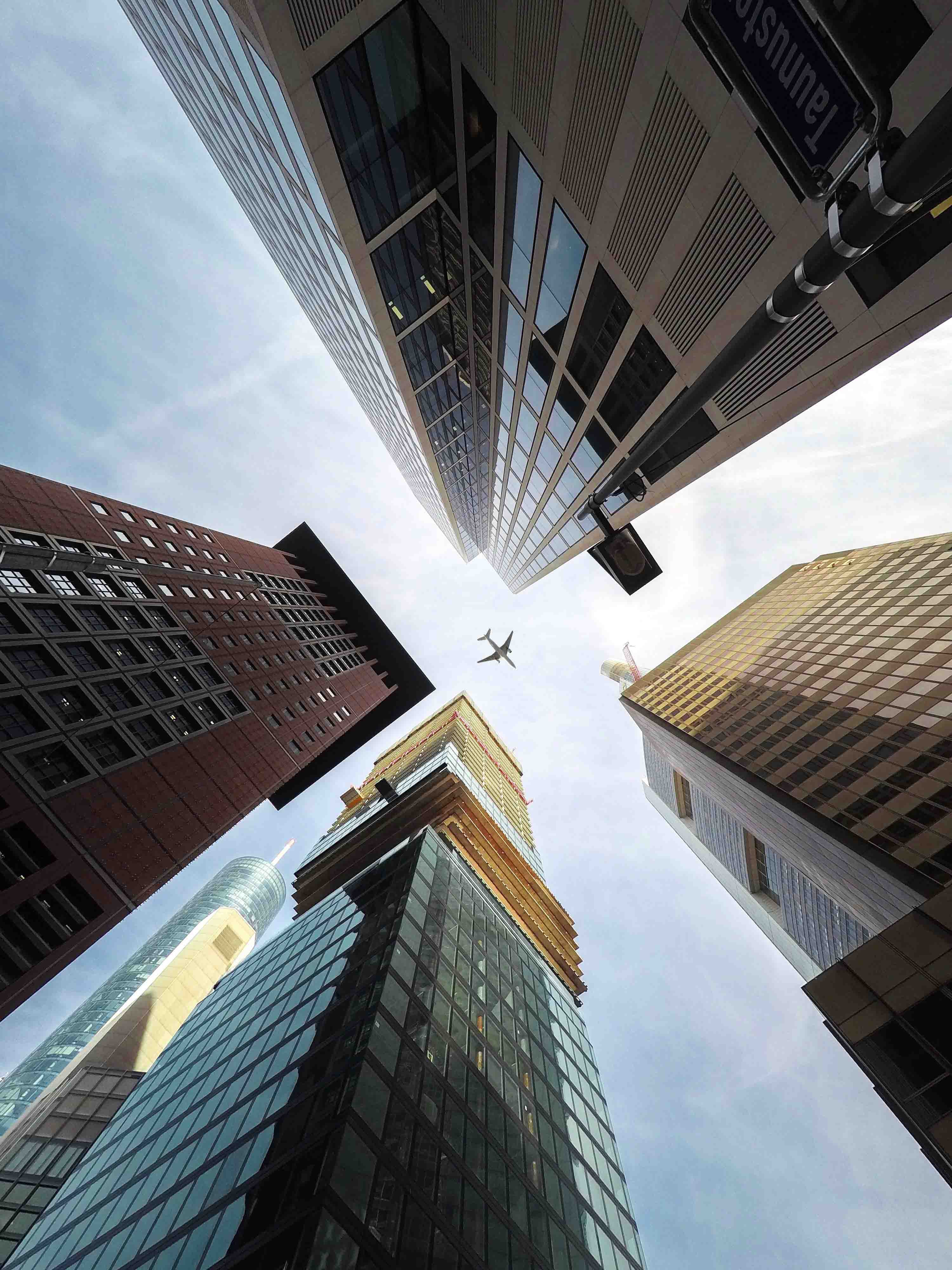A plane flying above skyscrapers.