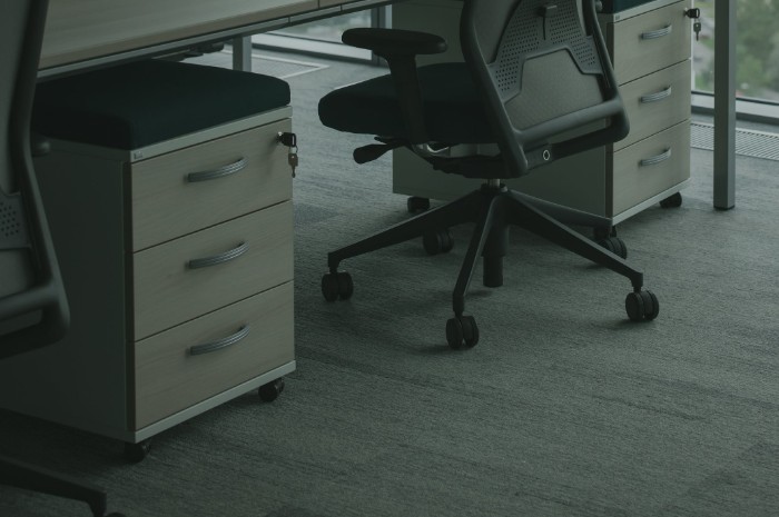 An office chair pulled into a desk on a carpet