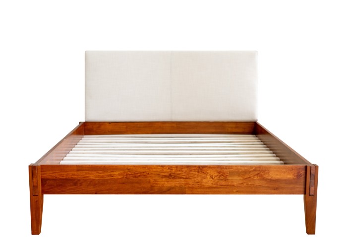 A brown stained bed frame without a mattress with a headboard on a white background