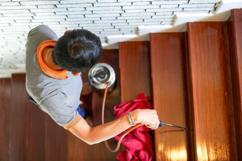 Man cleaning his stairs inside of his home.