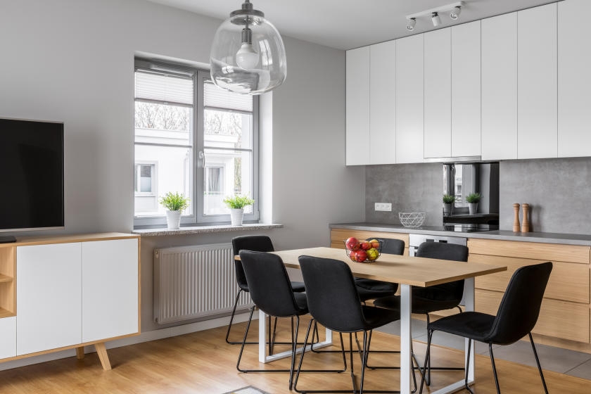 Kitchen and dining room with light gray wall and black accents