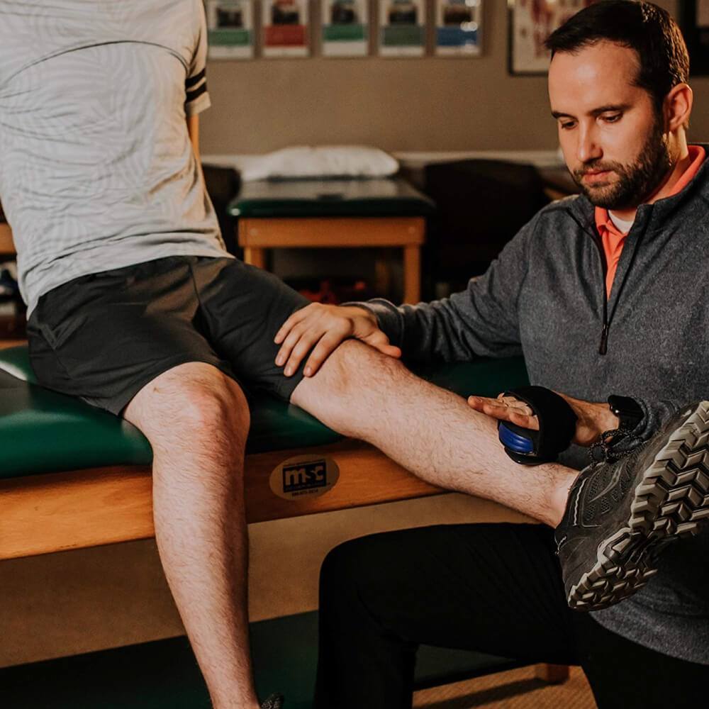 physiotherapist measuring leg strength using dynamometer