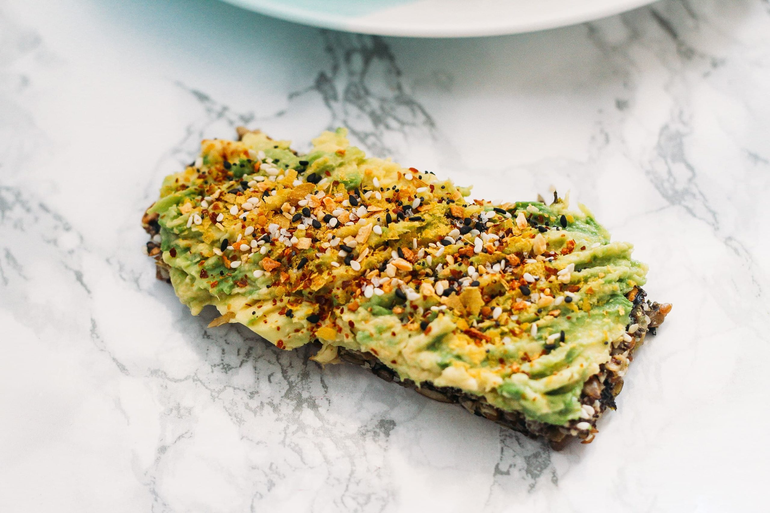super seed crackers with avocado on top