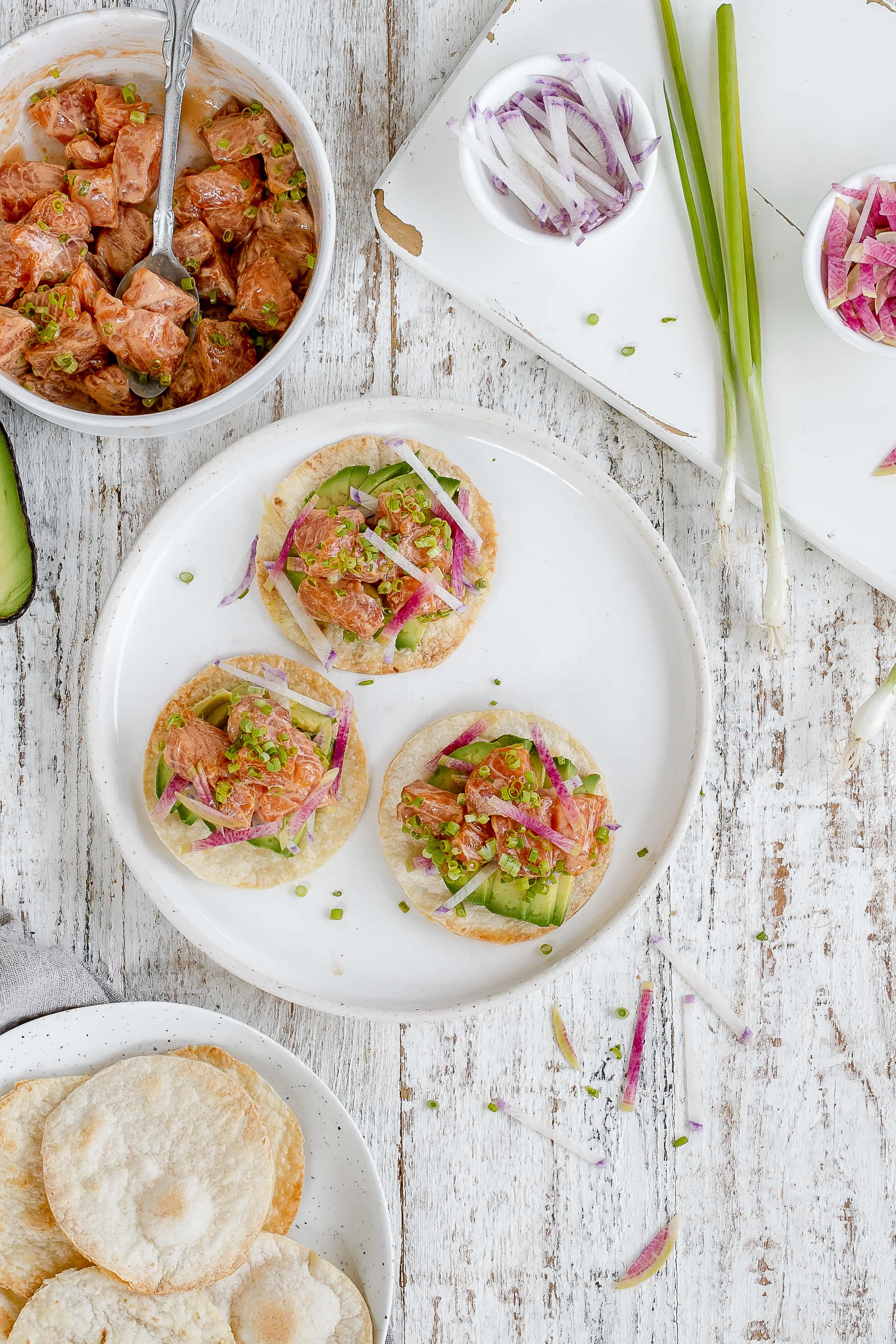 salmon tostadas on a plate with toppings.
