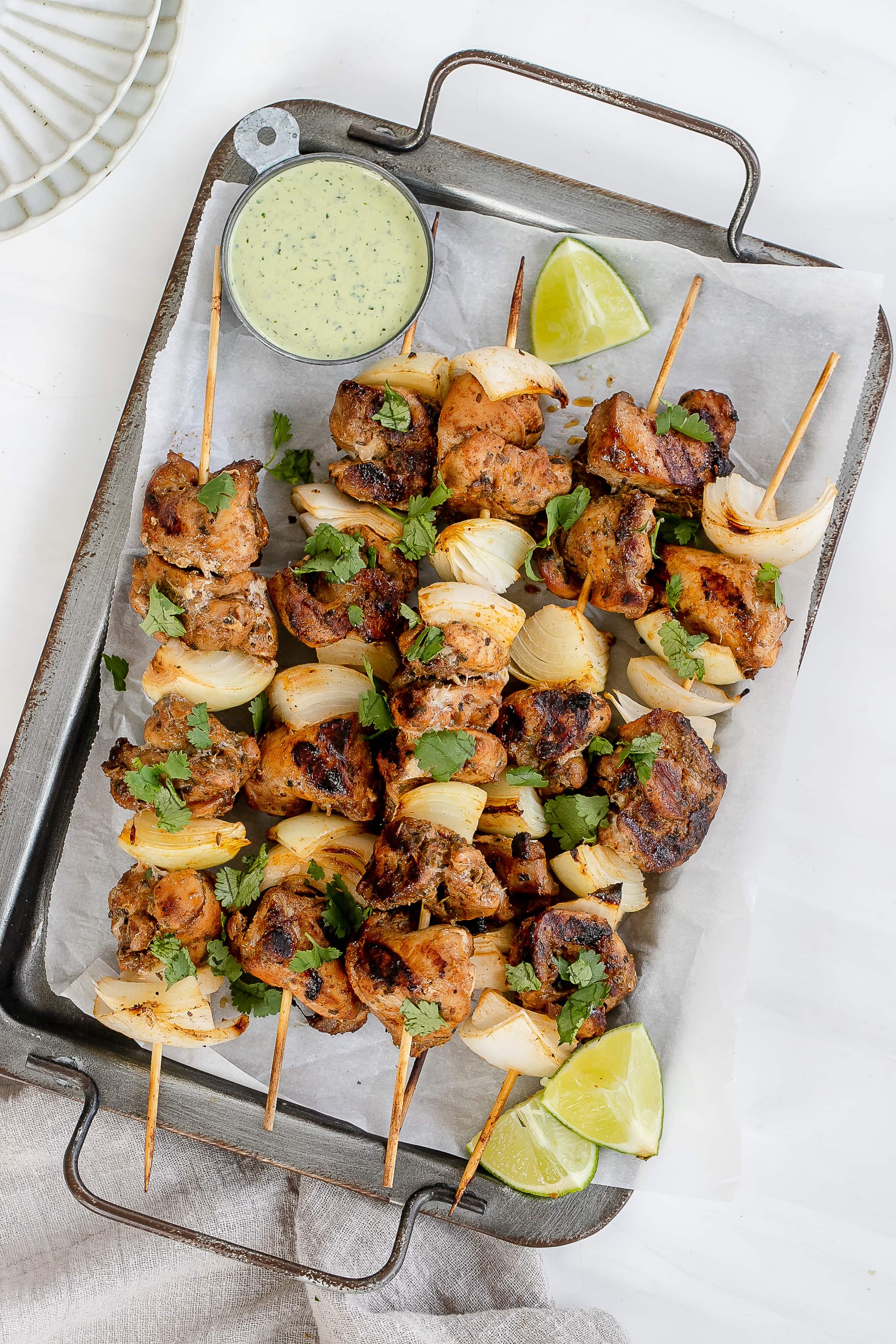 Peruvian chicken skewers on baking sheet.