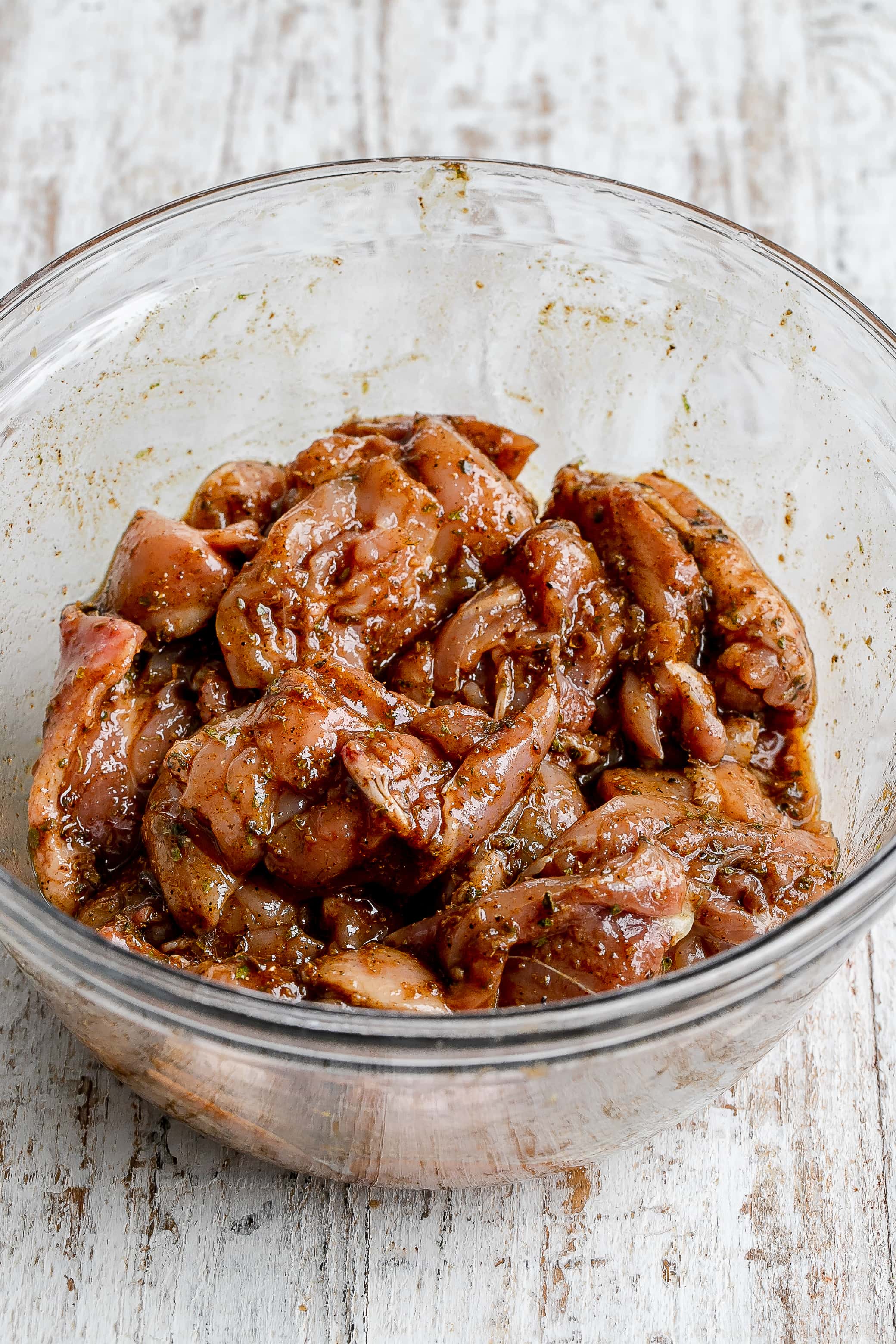 chicken in bowl with marinade. 