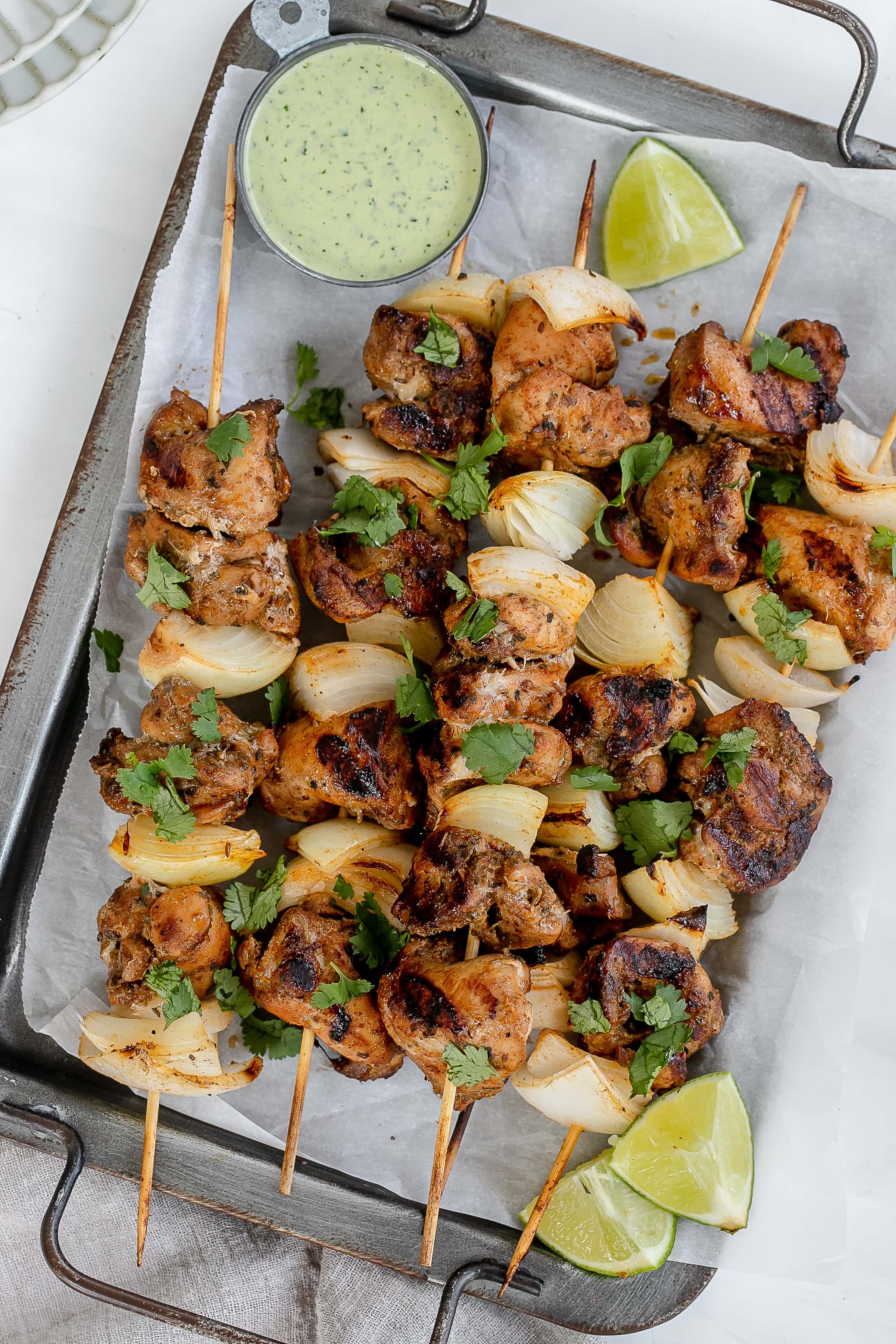 Peruvian chicken skewers on baking sheet.