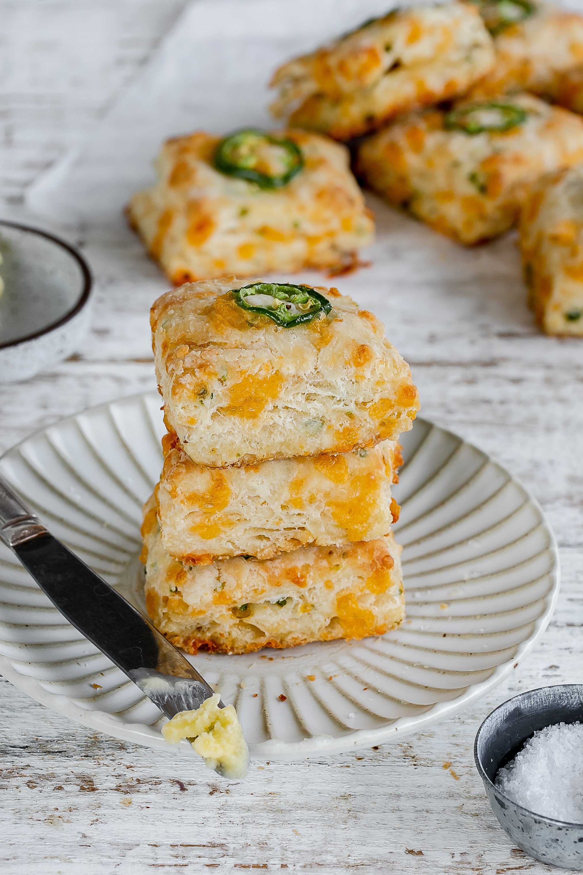 jalapeño cheddar biscuits layered on a plate.
