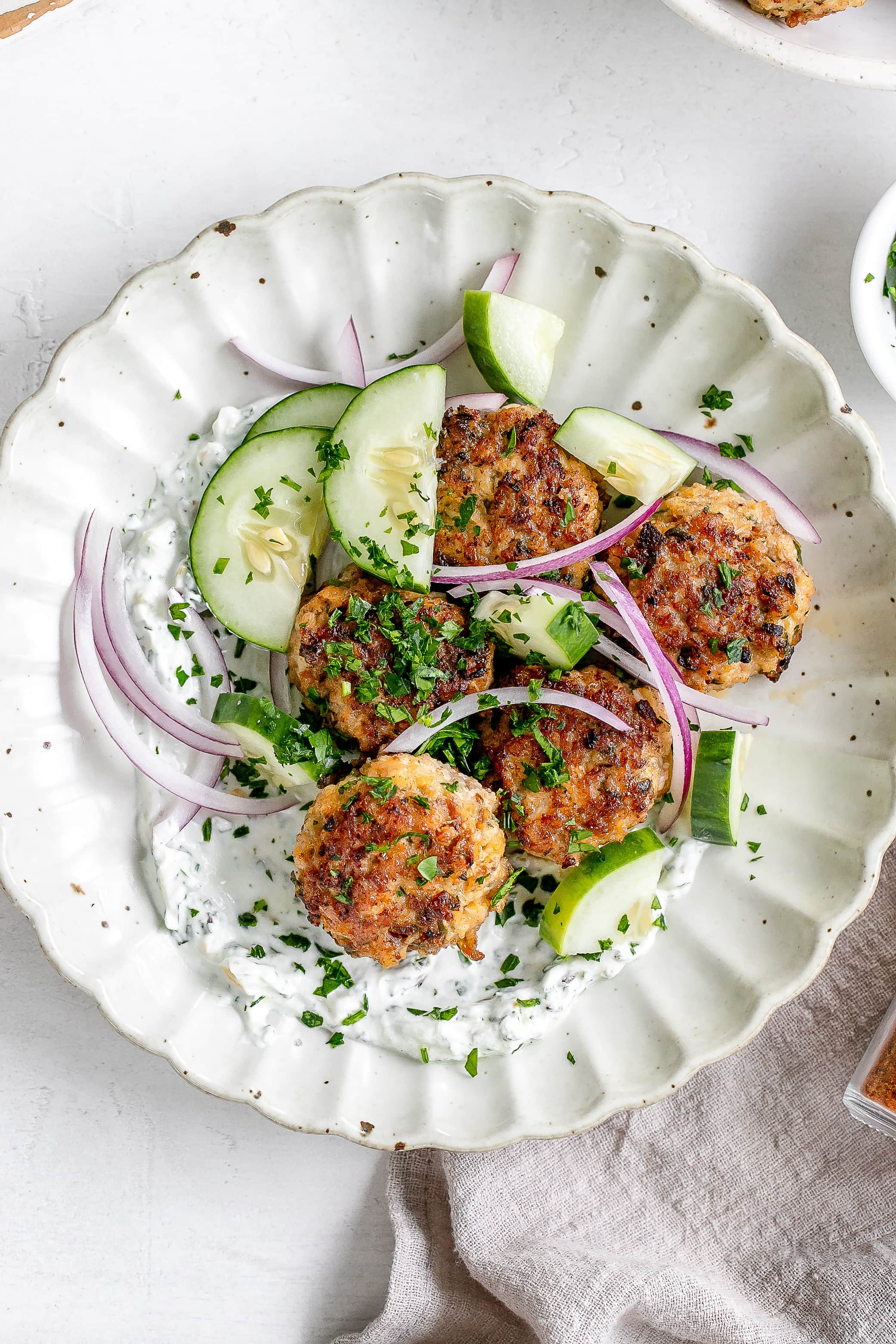 Moroccan chicken meatballs on a plate with yogurt dip.