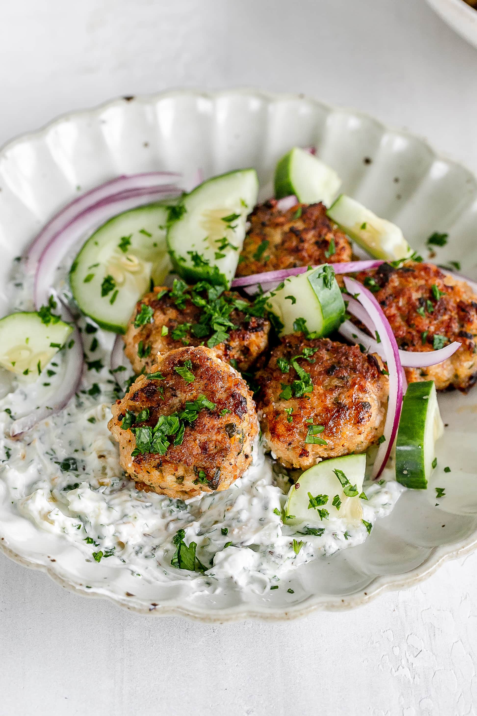 Moroccan chicken meatballs on a plate with yogurt dip.