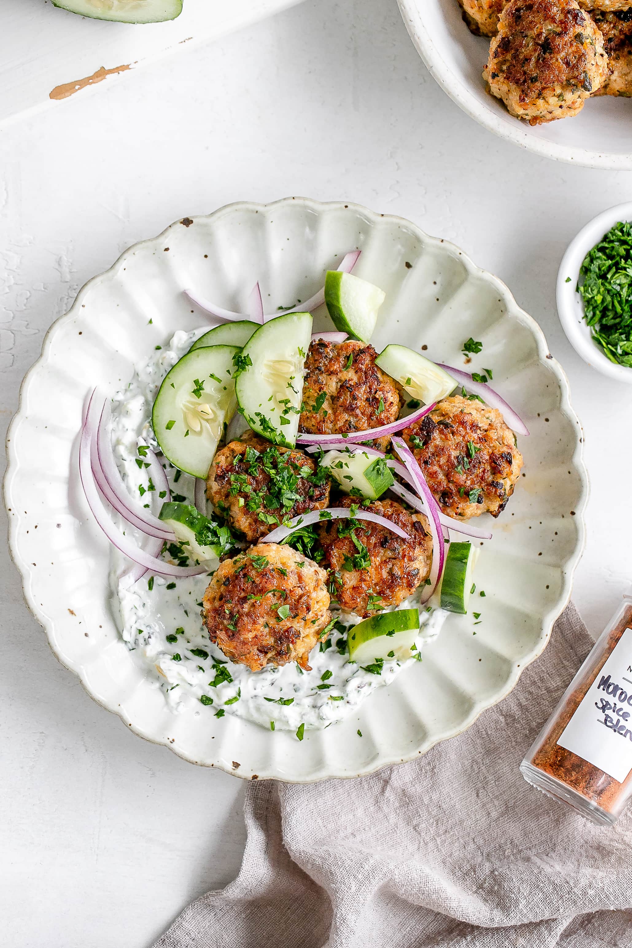 Moroccan chicken meatballs on a plate with yogurt dip.