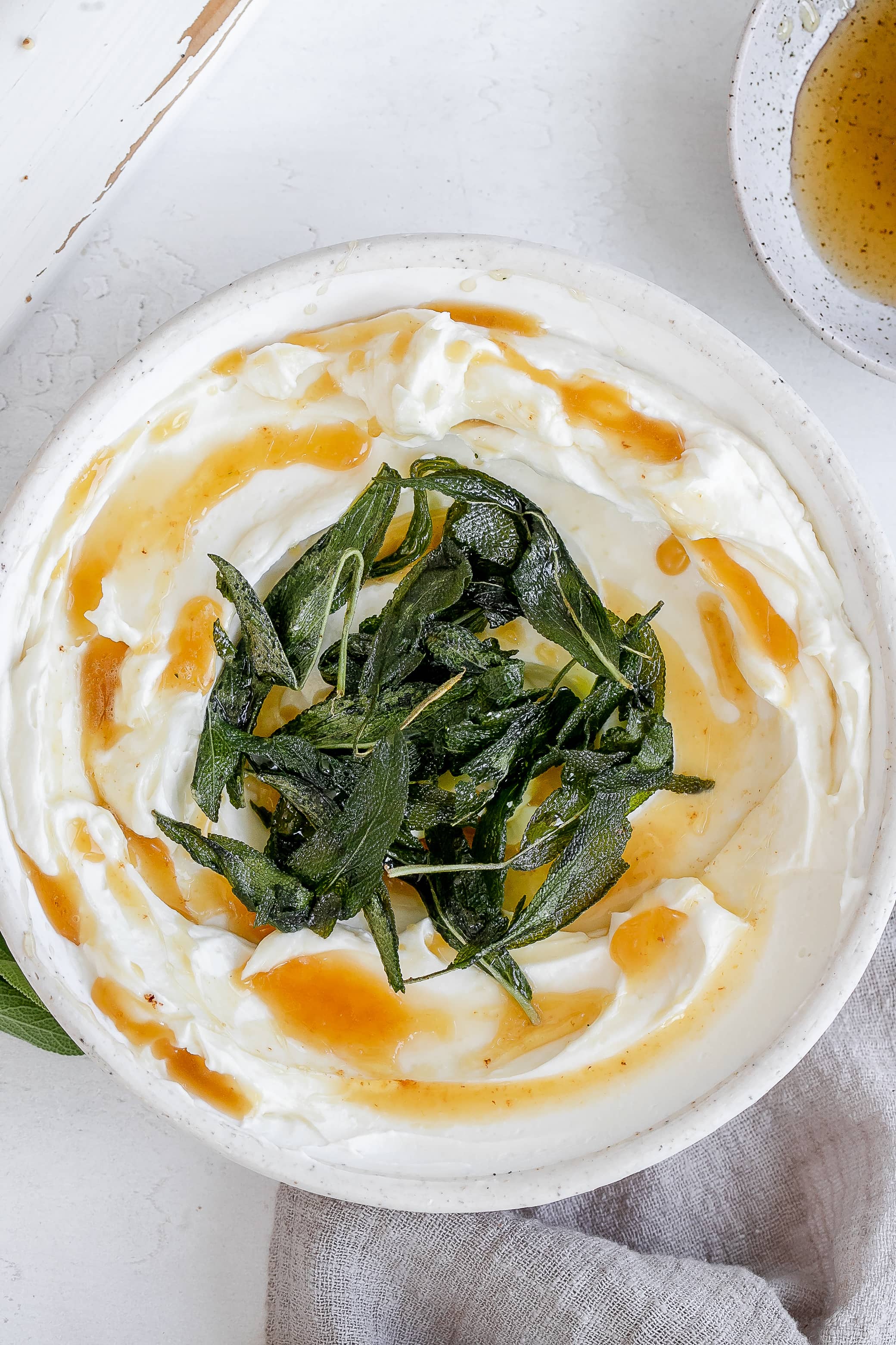 whipped ricotta in a bowl with butter and sage.