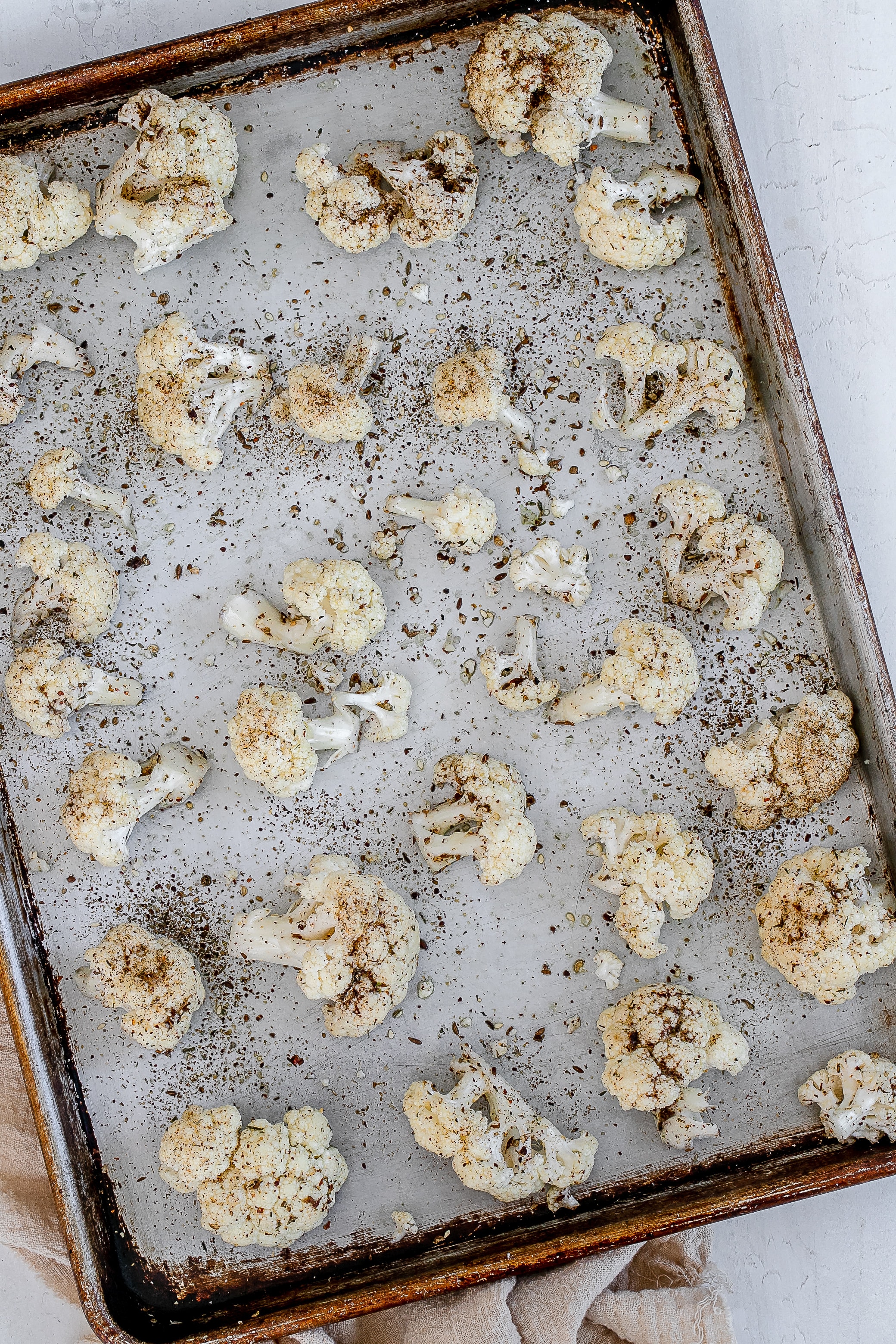 cauliflower florets with spices on baking sheet.