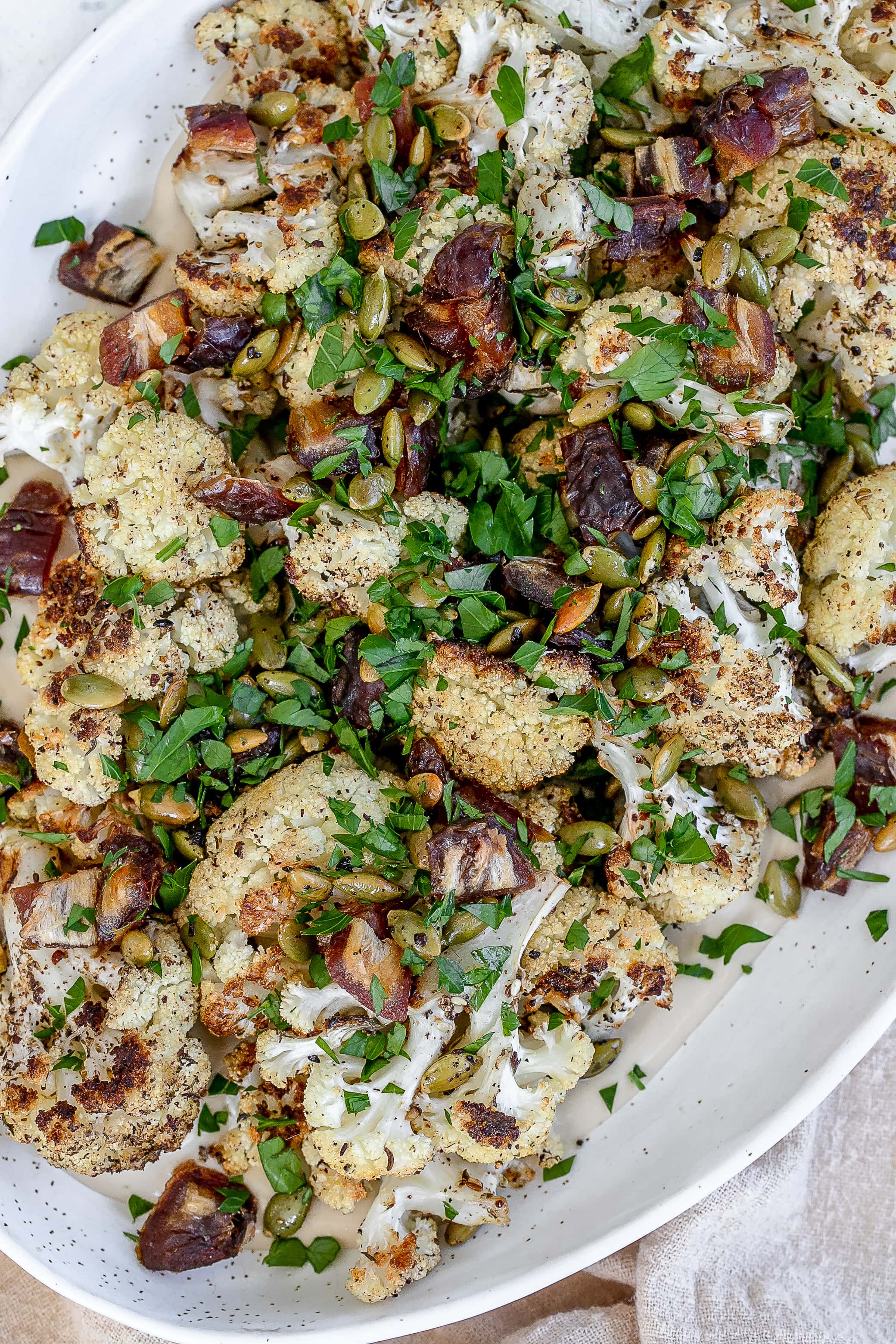 roasted cauliflower with tahini on a platter. 