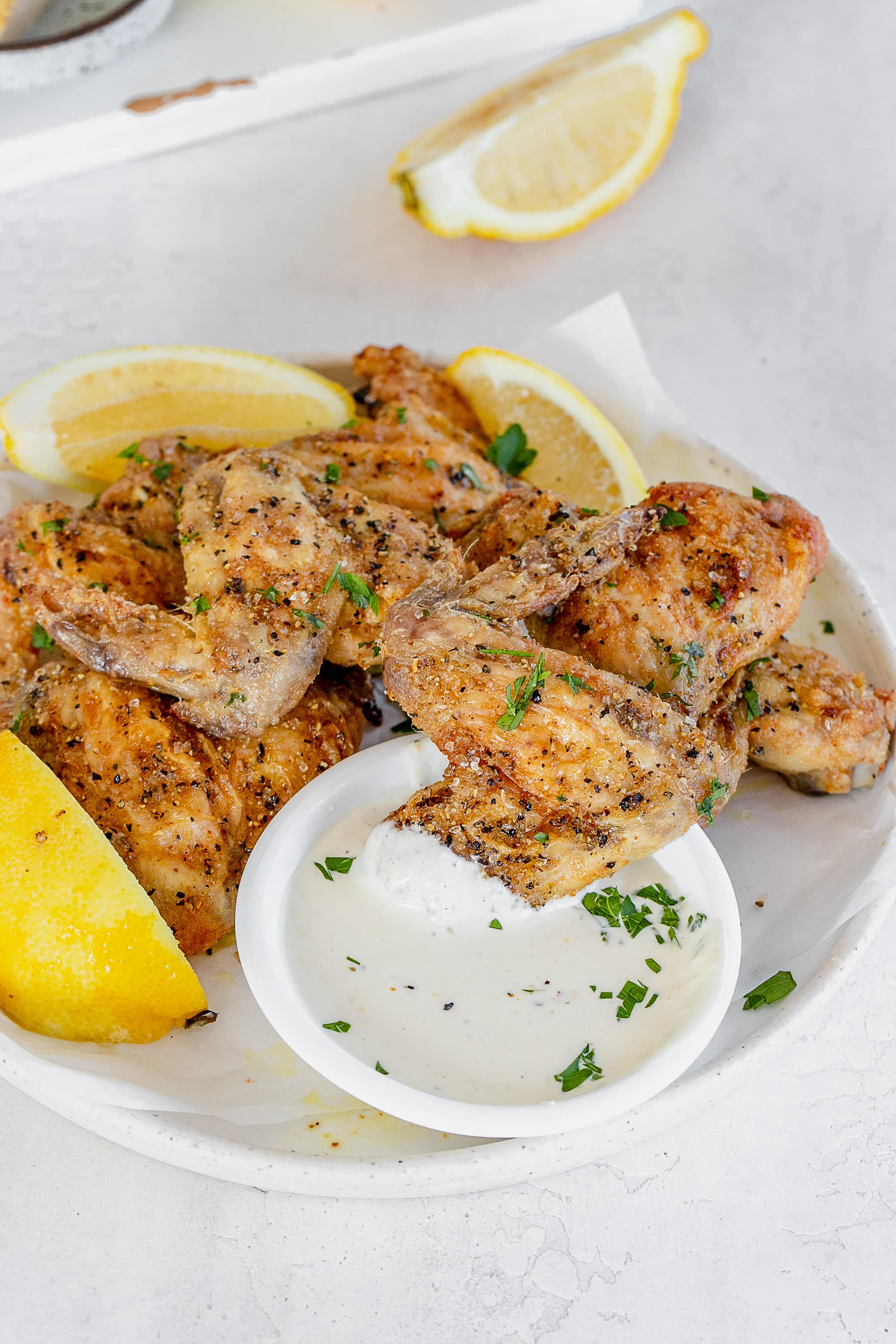 lemon pepper chicken wing in dipping sauce.