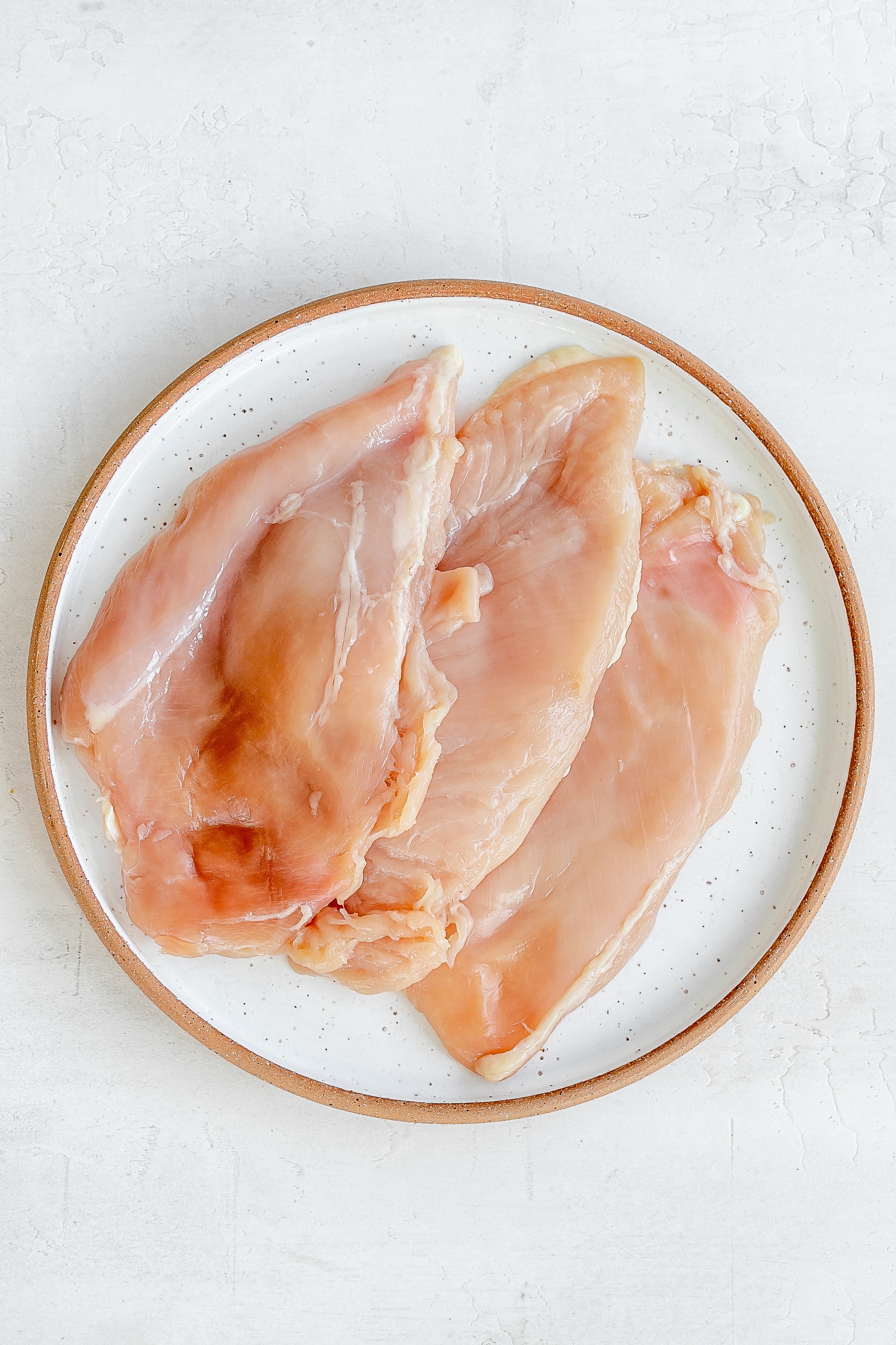 chicken pounded thin on a plate.