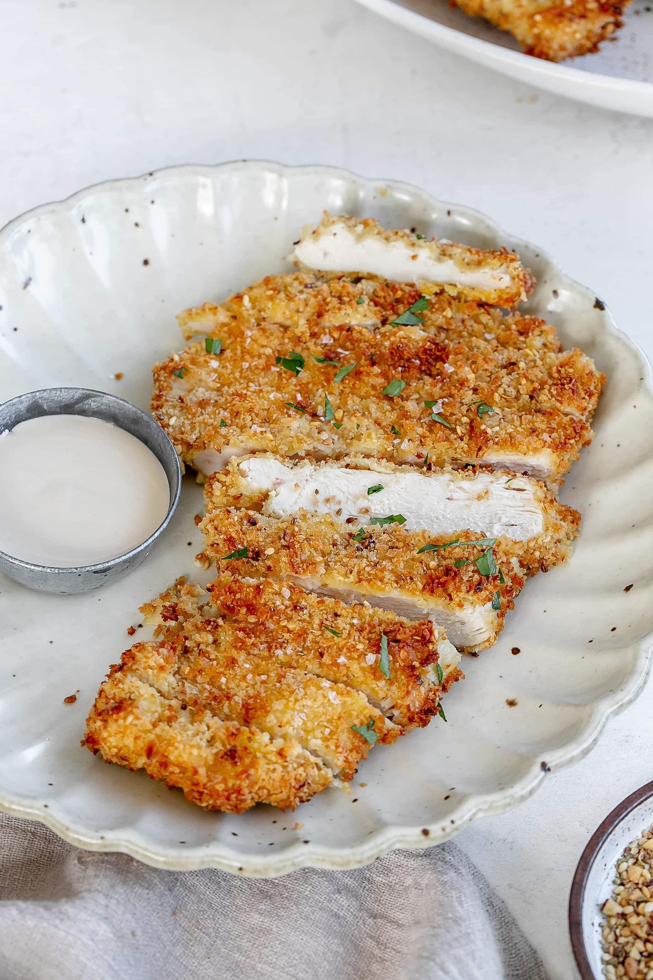 air fryer chicken schnitzel on a plate with tahini dip.