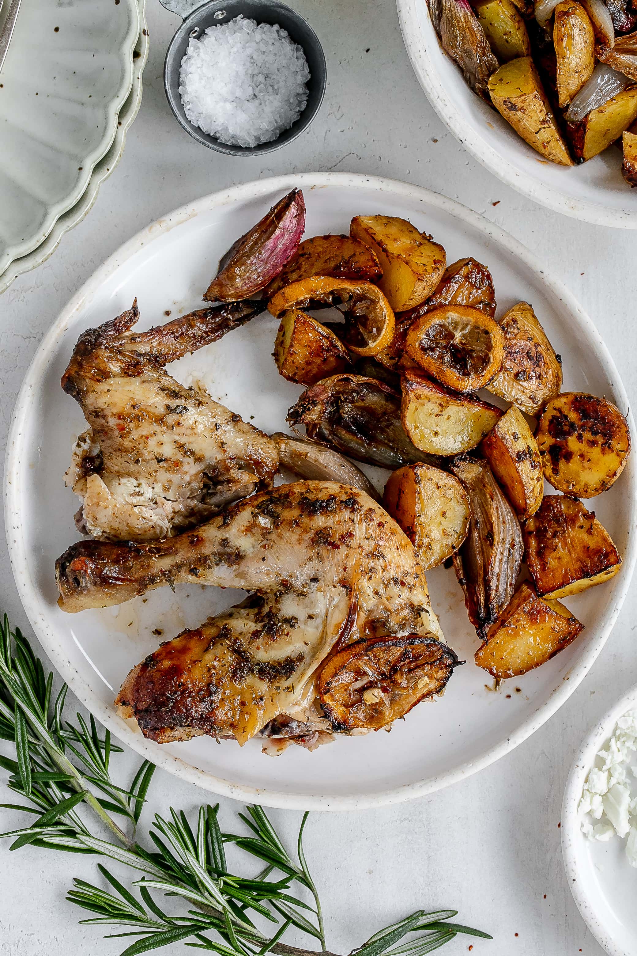 Greek roast chicken on a plate with potatoes.