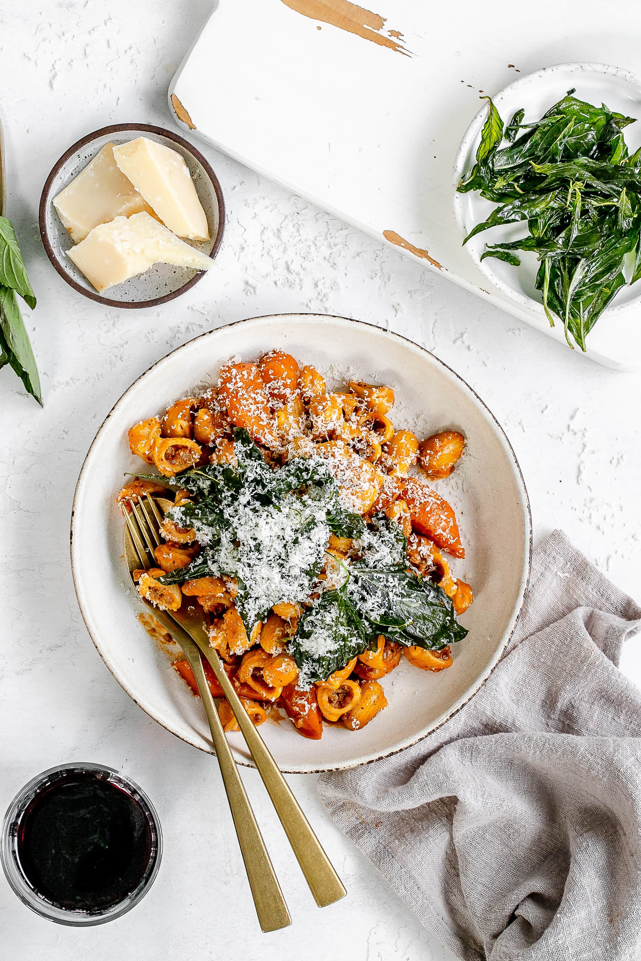 Thai bolognese on a plate topped with cheese and basil.