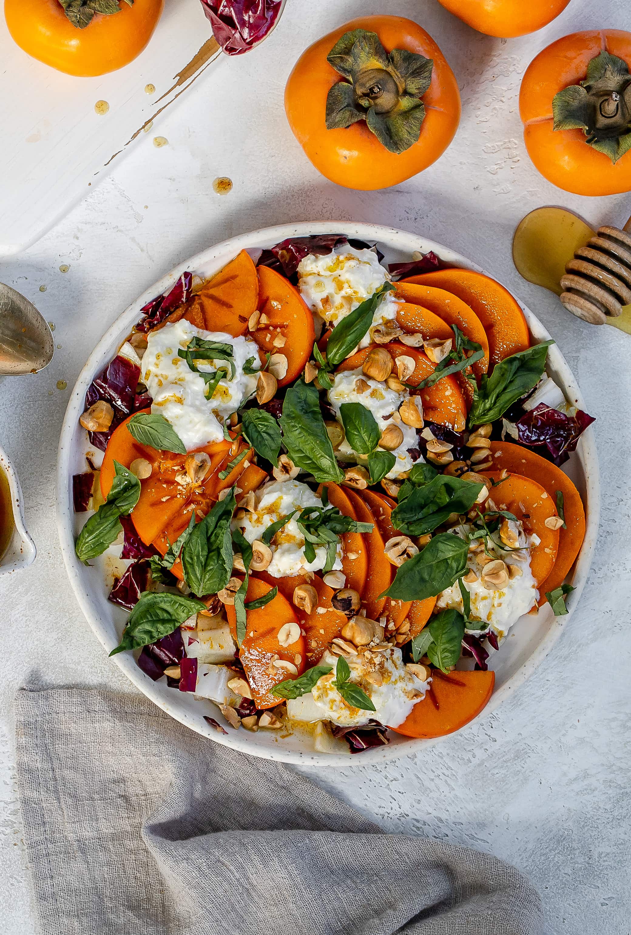 persimmon salad with burrata on a plate.