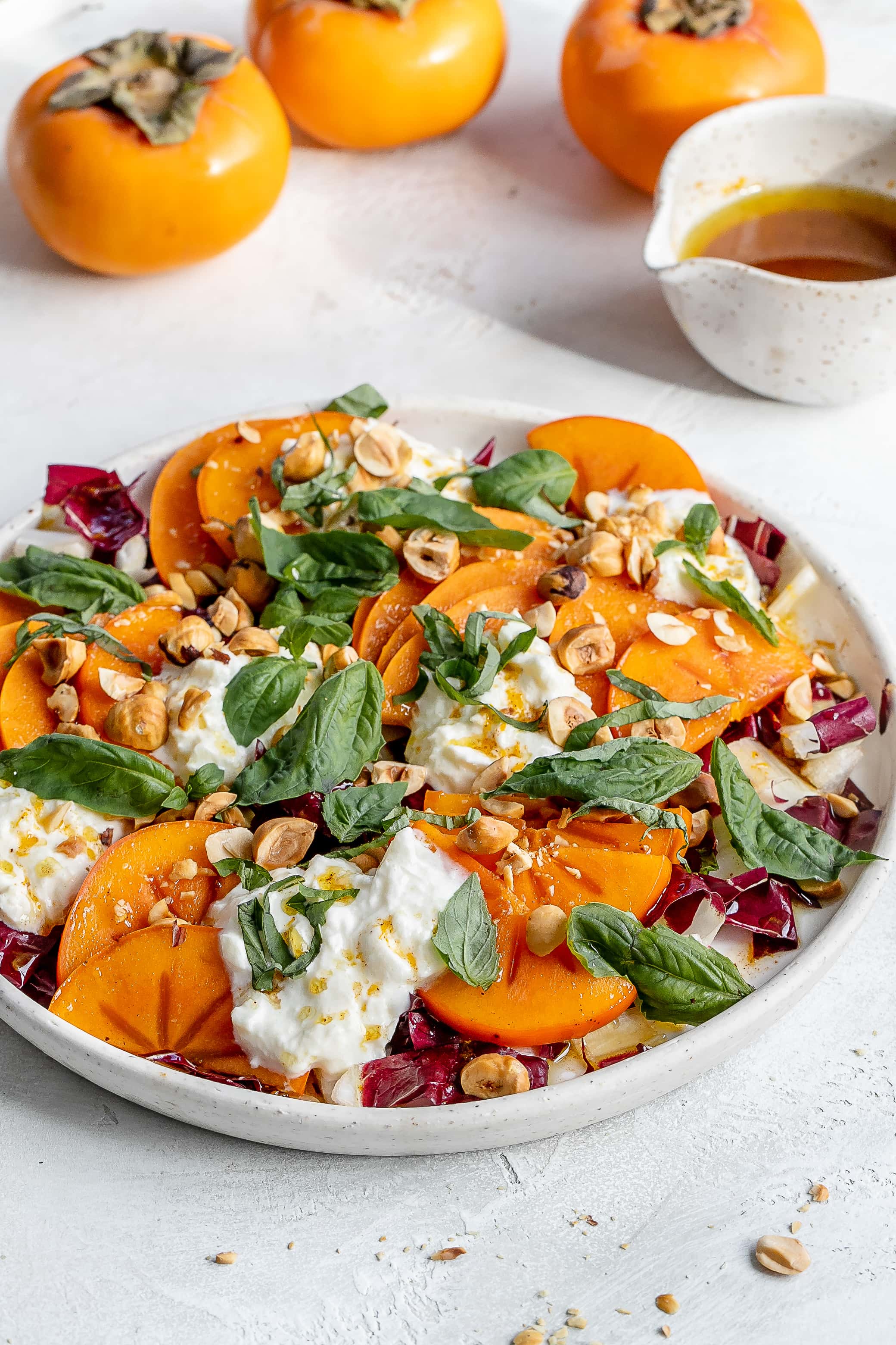 persimmon salad with burrata on a plate.