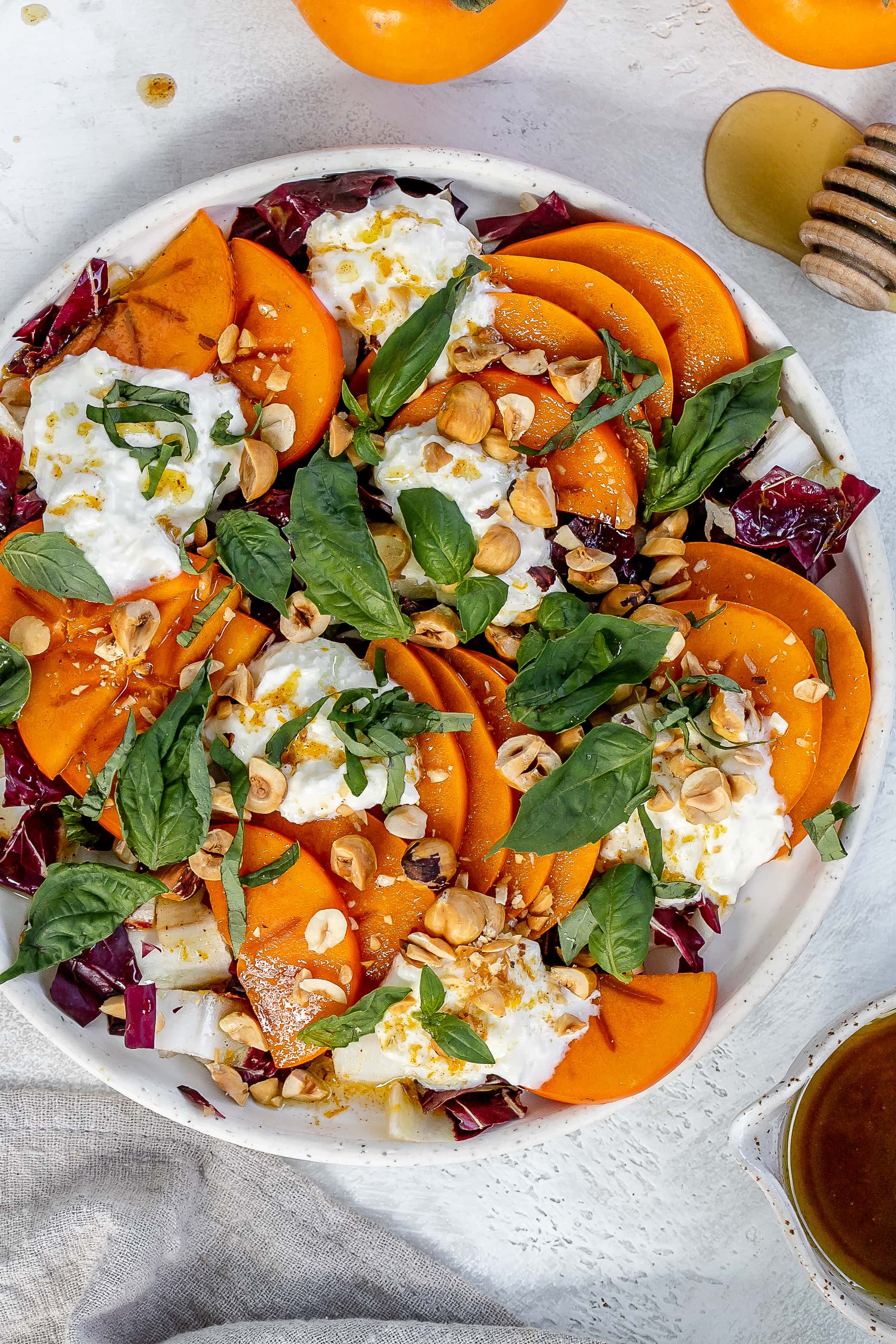 persimmon salad with burrata on a plate.