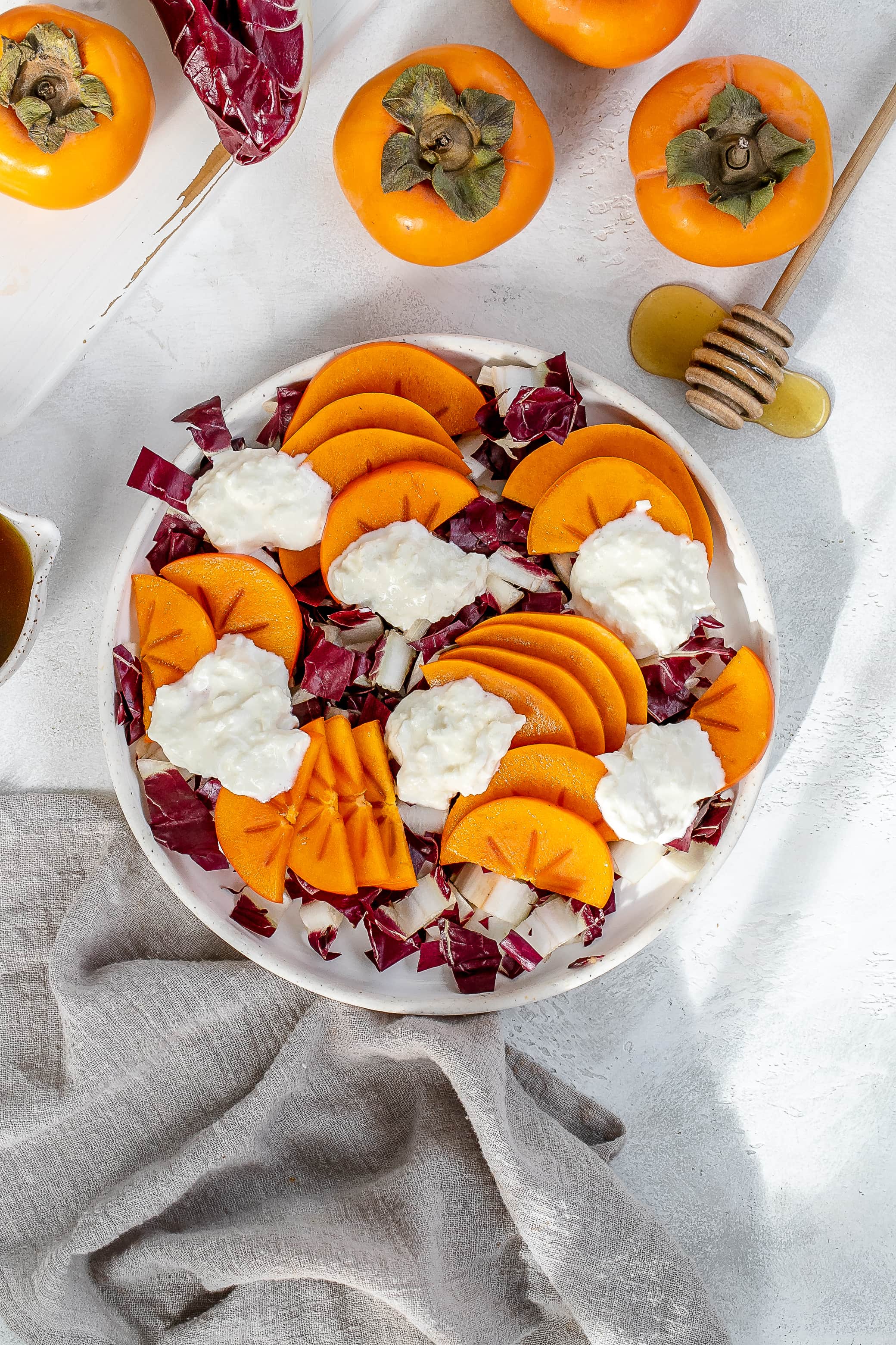 persimmon salad with burrata on a plate.