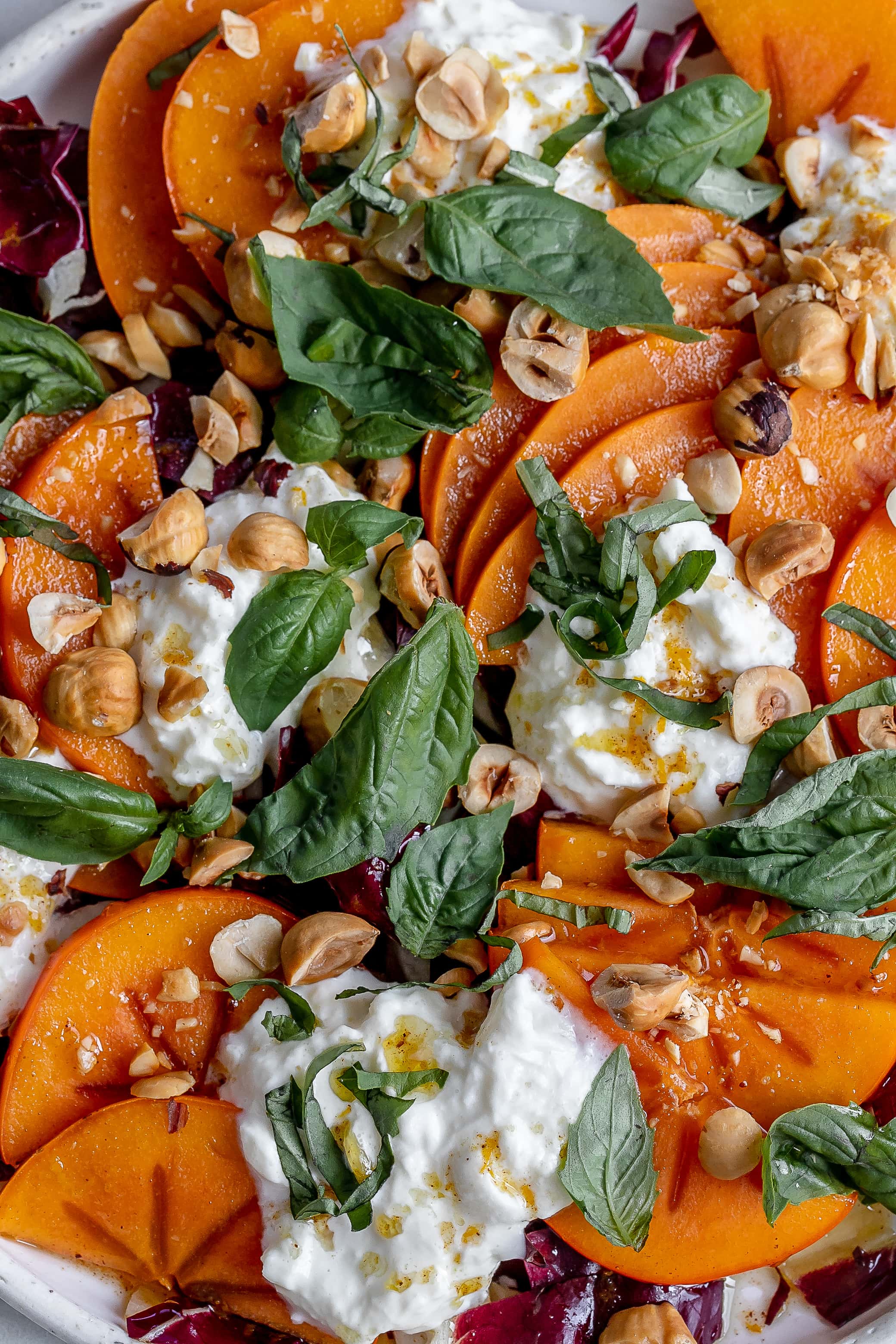 persimmon salad with burrata on a plate.