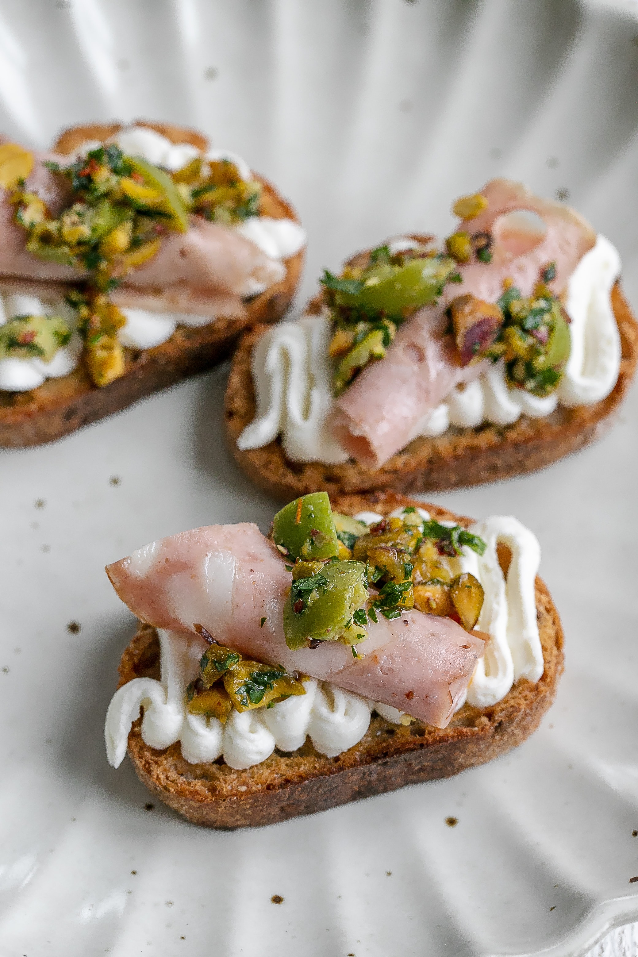 whipped ricotta on a crostini on a plate.