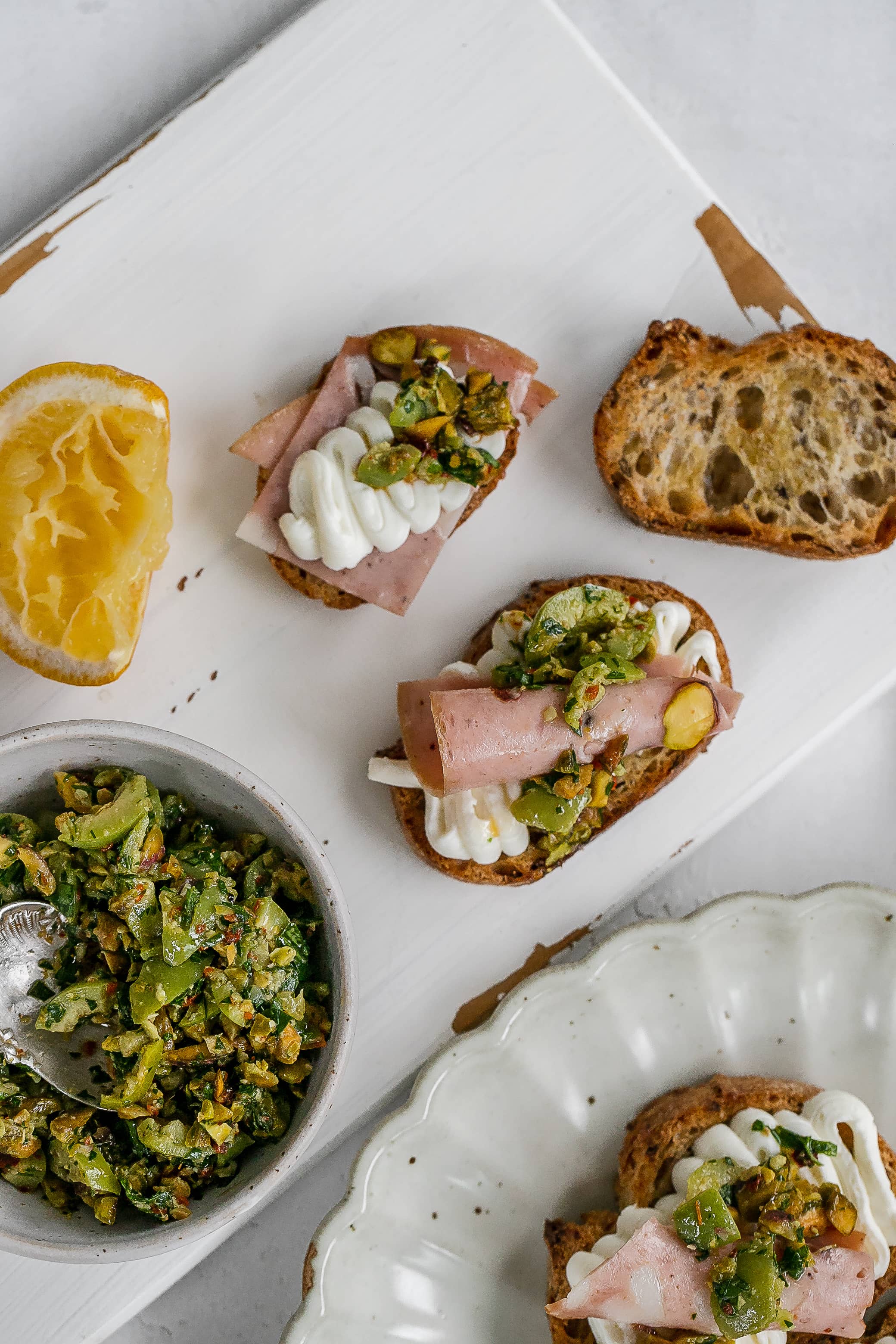 whipped ricotta on a crostini on a cutting board.
