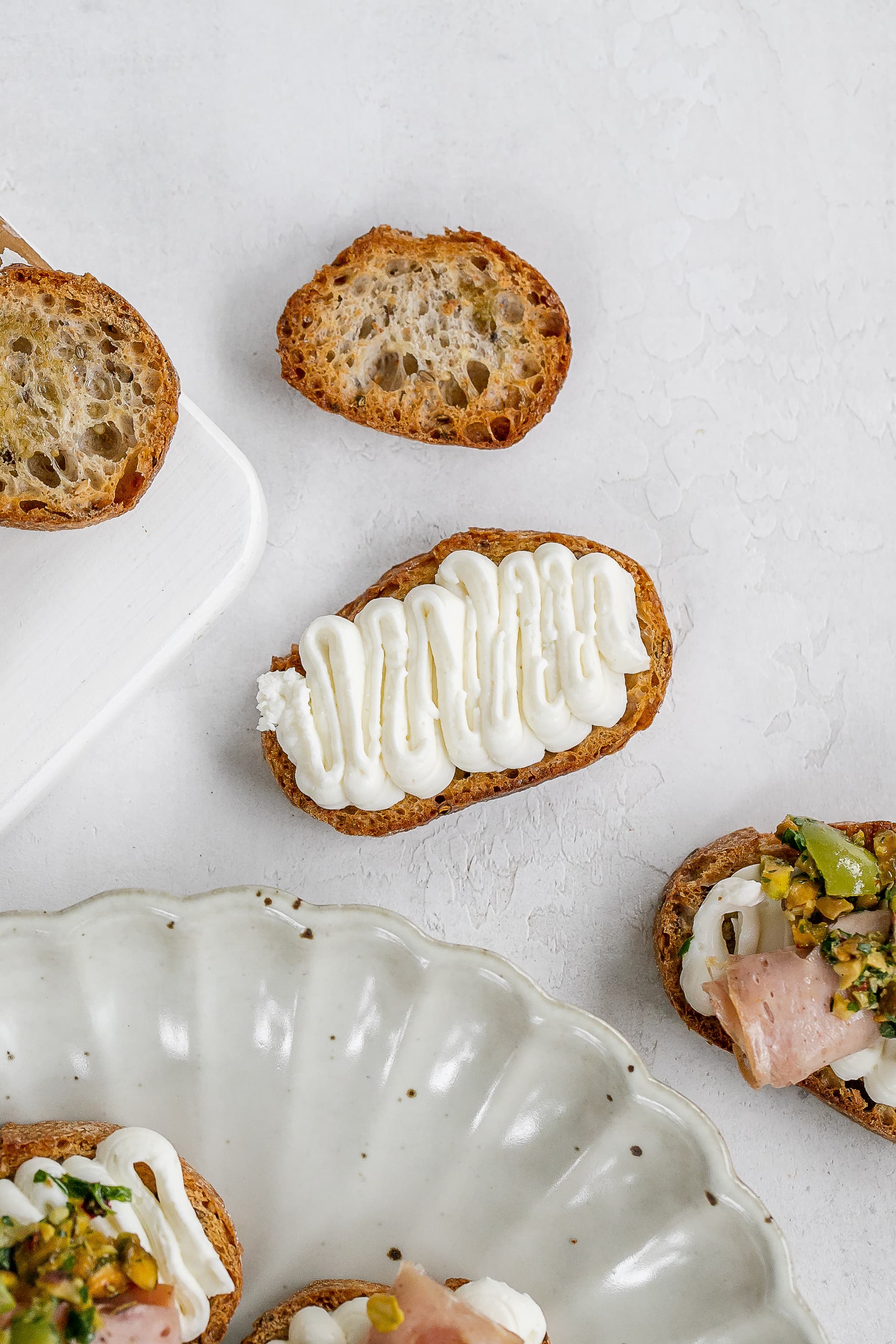 whipped ricotta on a crostini on a plate.