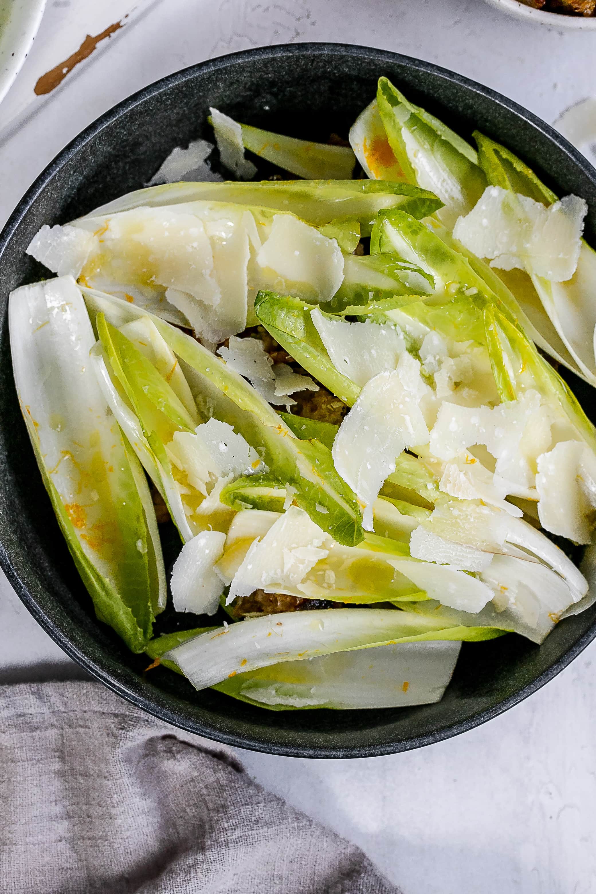 endive boats with filling underneath in bowl.
