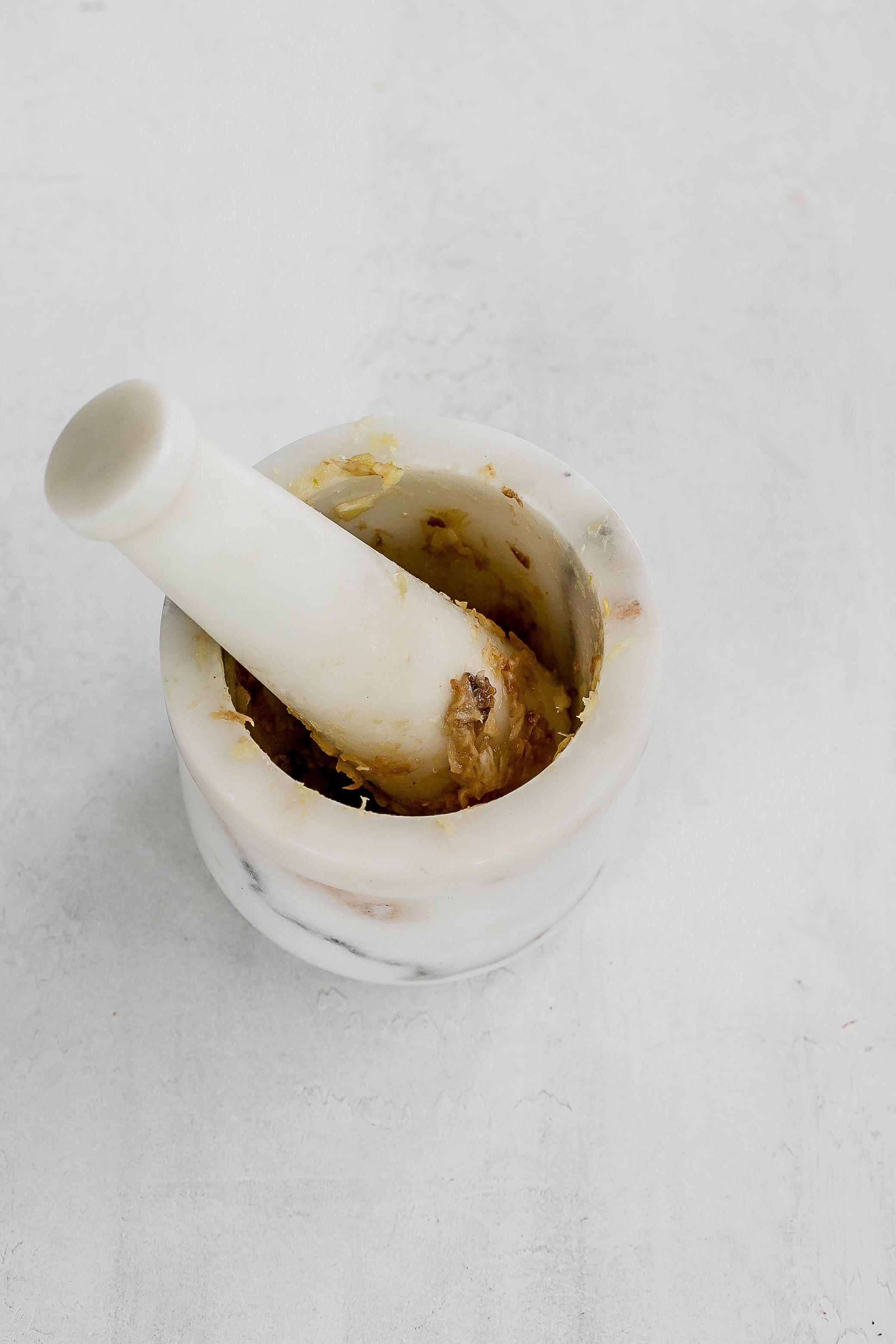 dressing ingredients in mortar and pestle. 