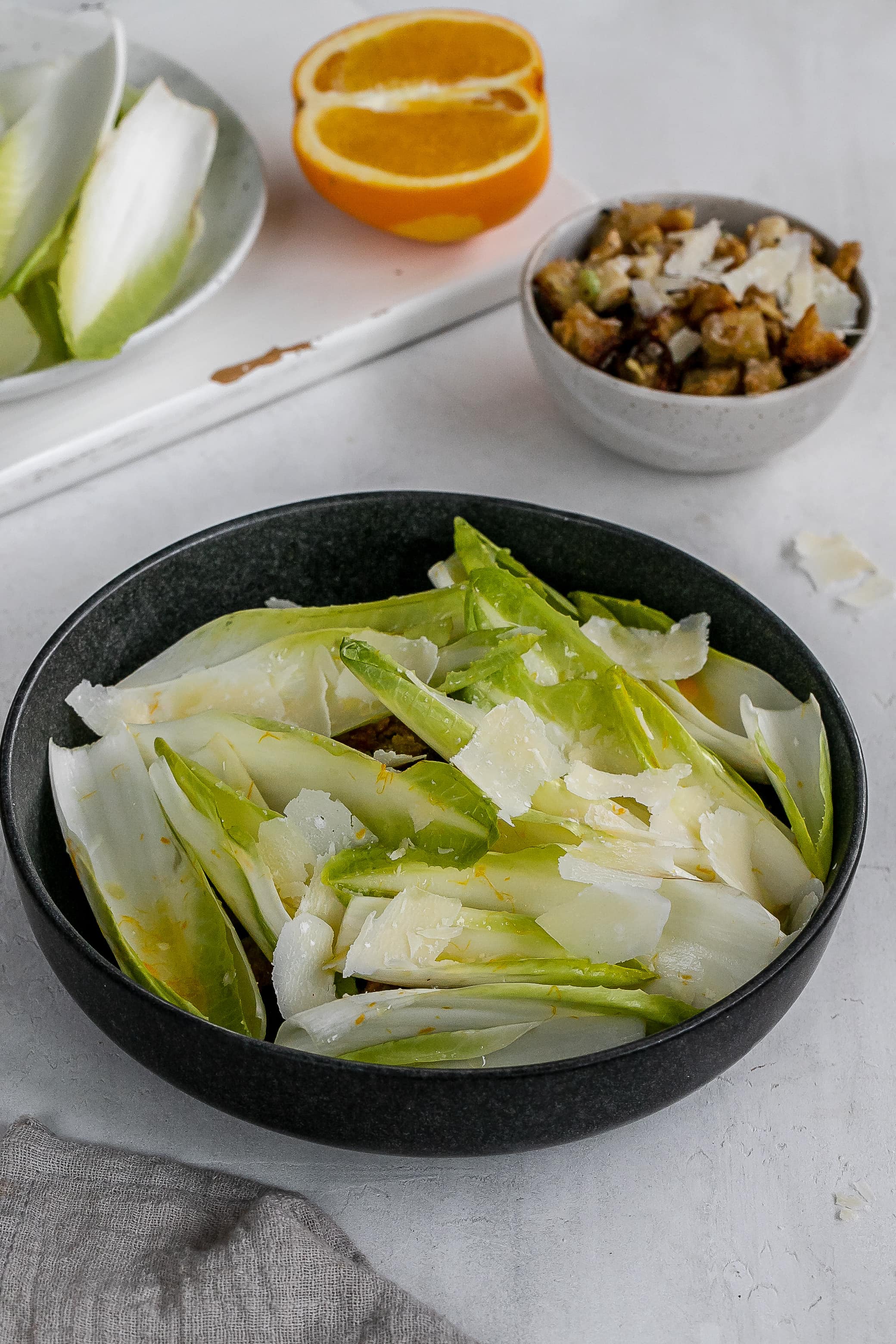 endive boats with filling underneath in bowl.