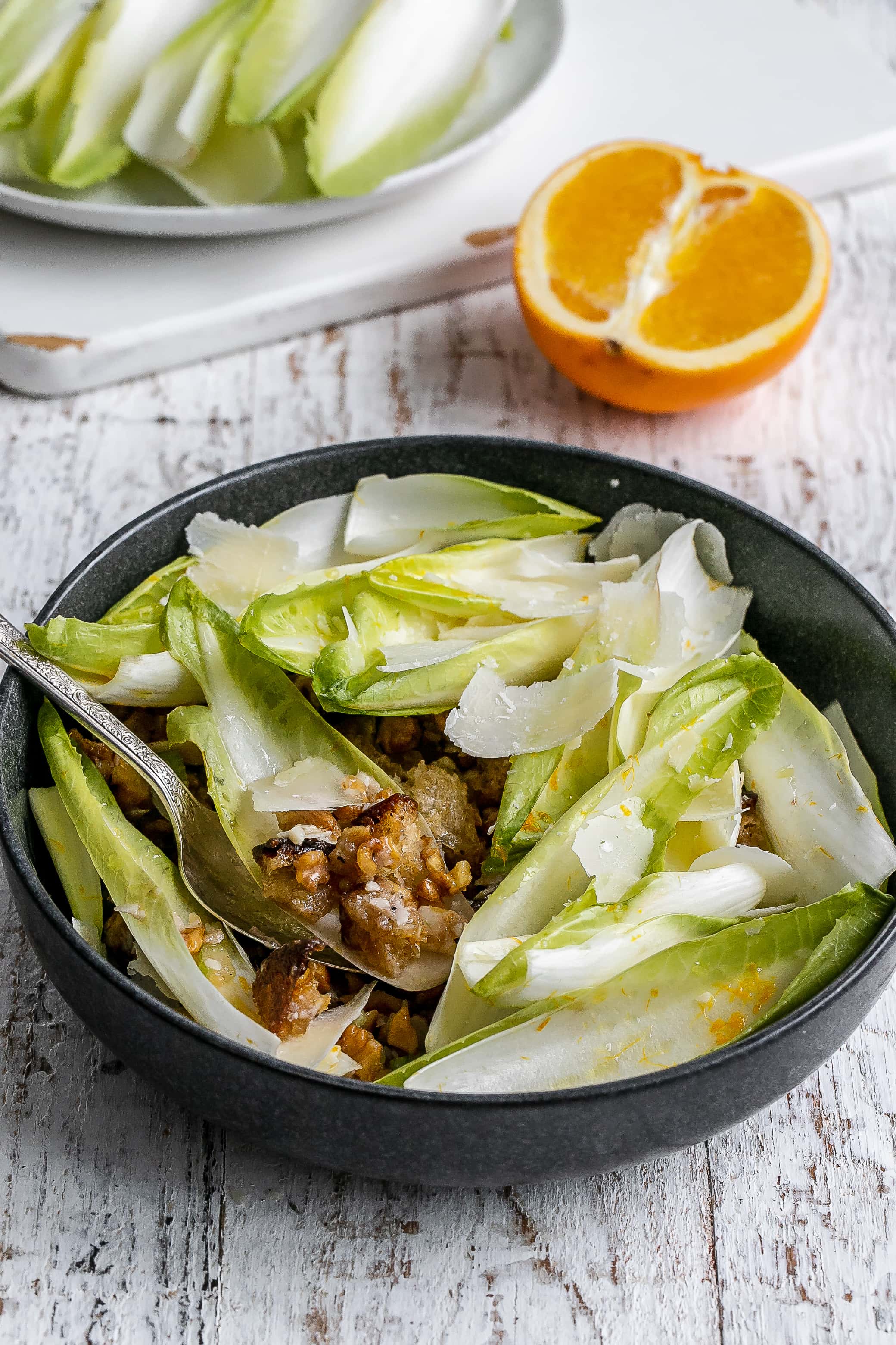 endive boats with filling underneath in bowl.