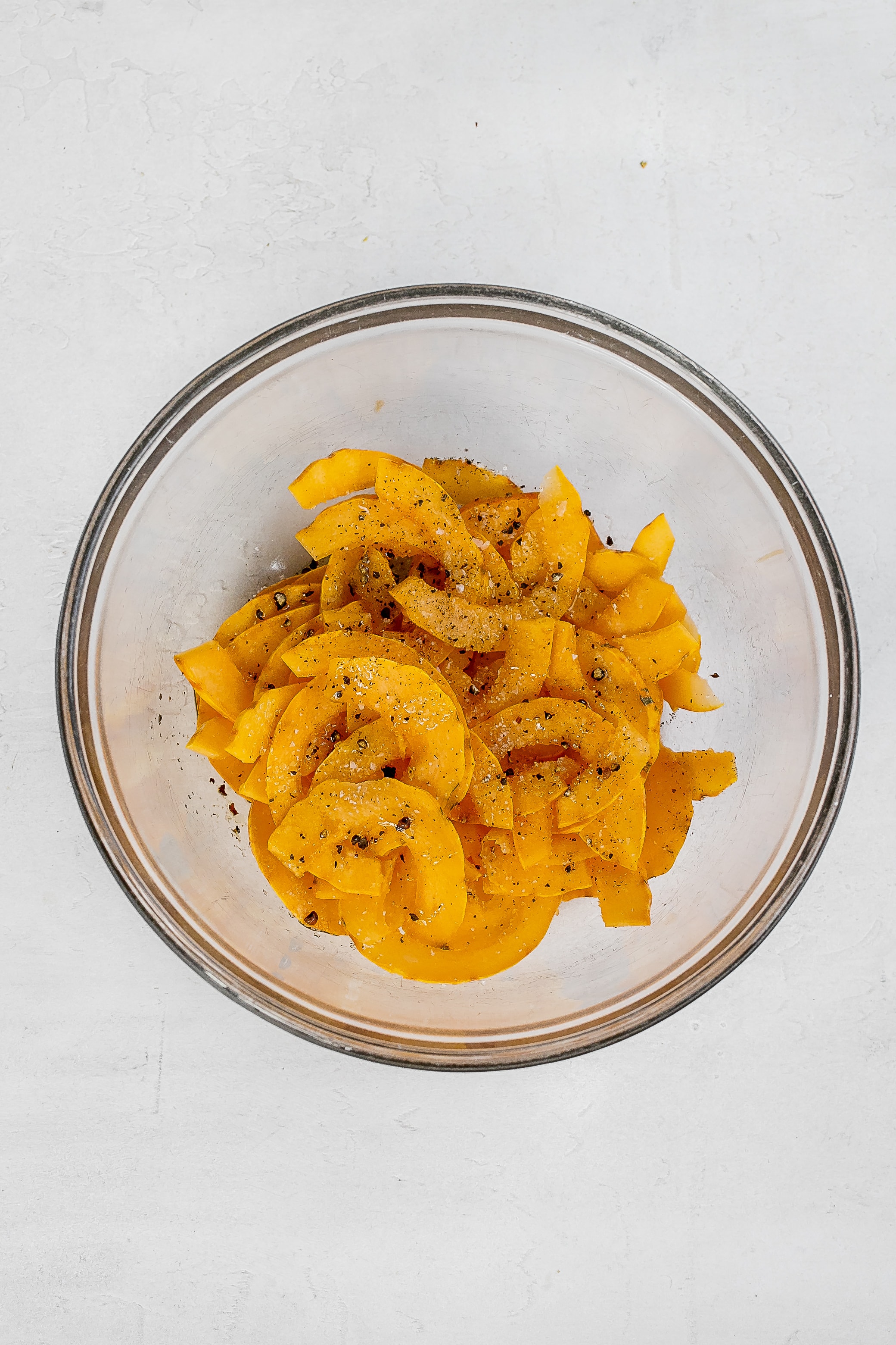 thinly sliced delicata squash in bowl.