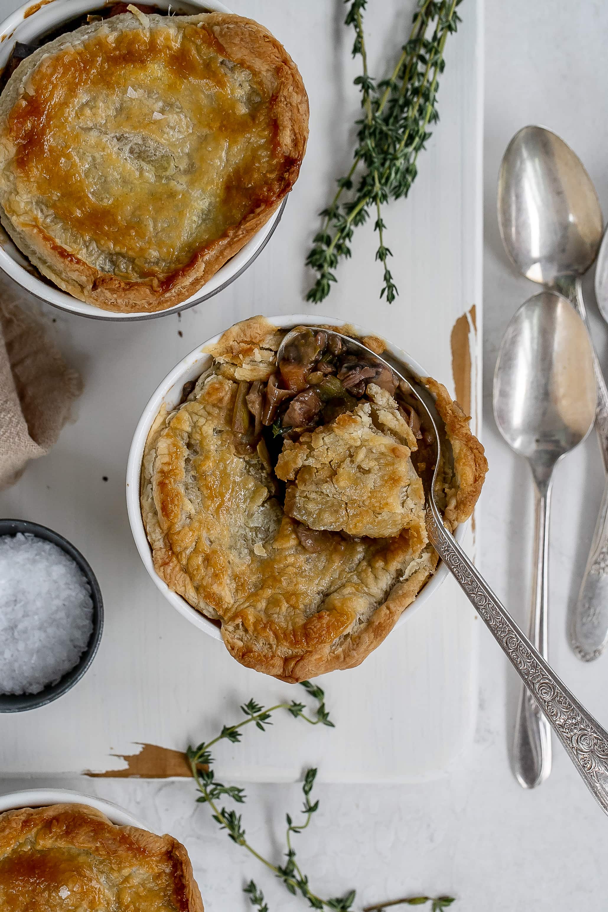 mushroom and lentil pot pies in ramekins on cutting board.