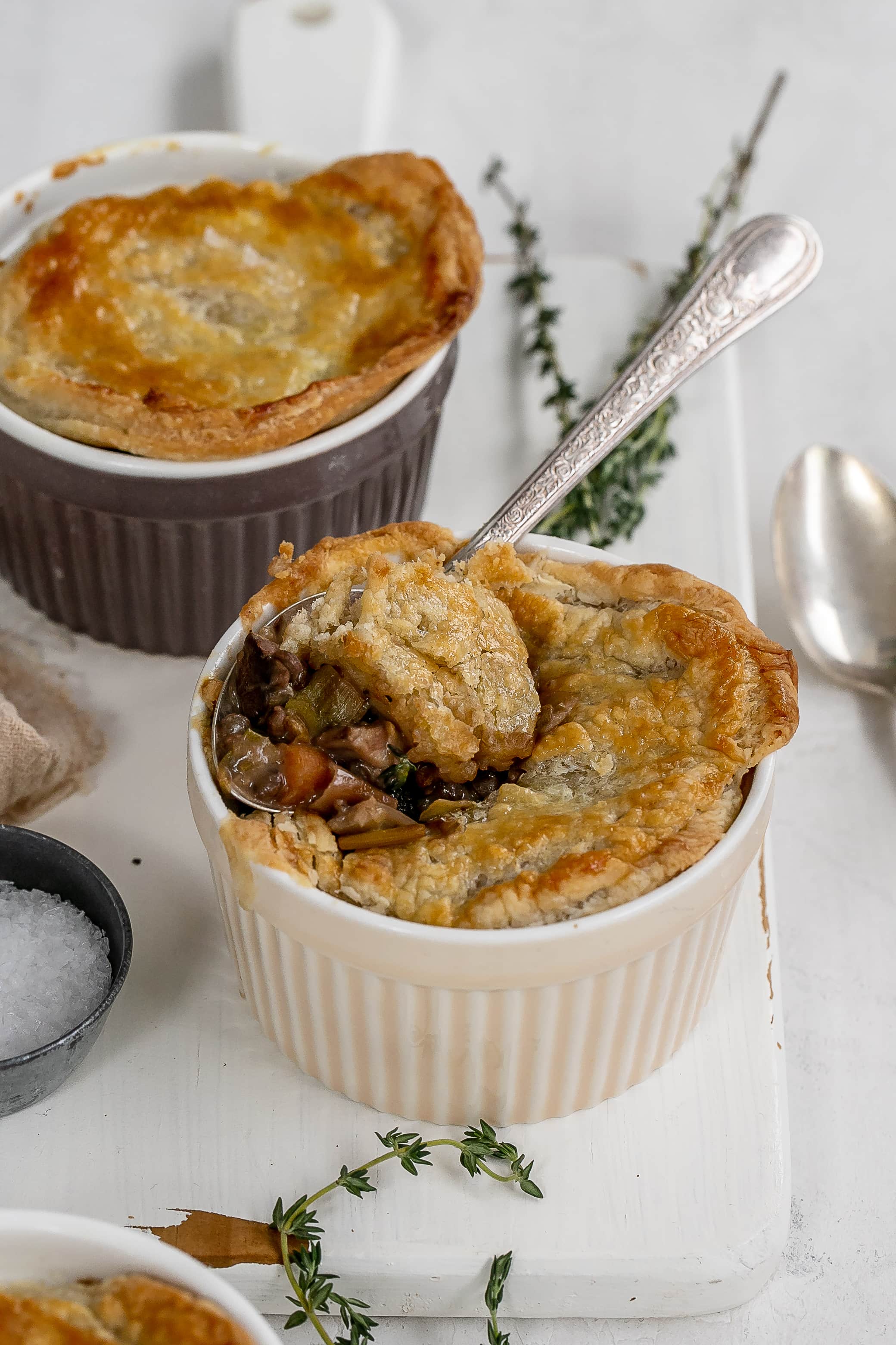mushroom and lentil pot pies in ramekins on cutting board.