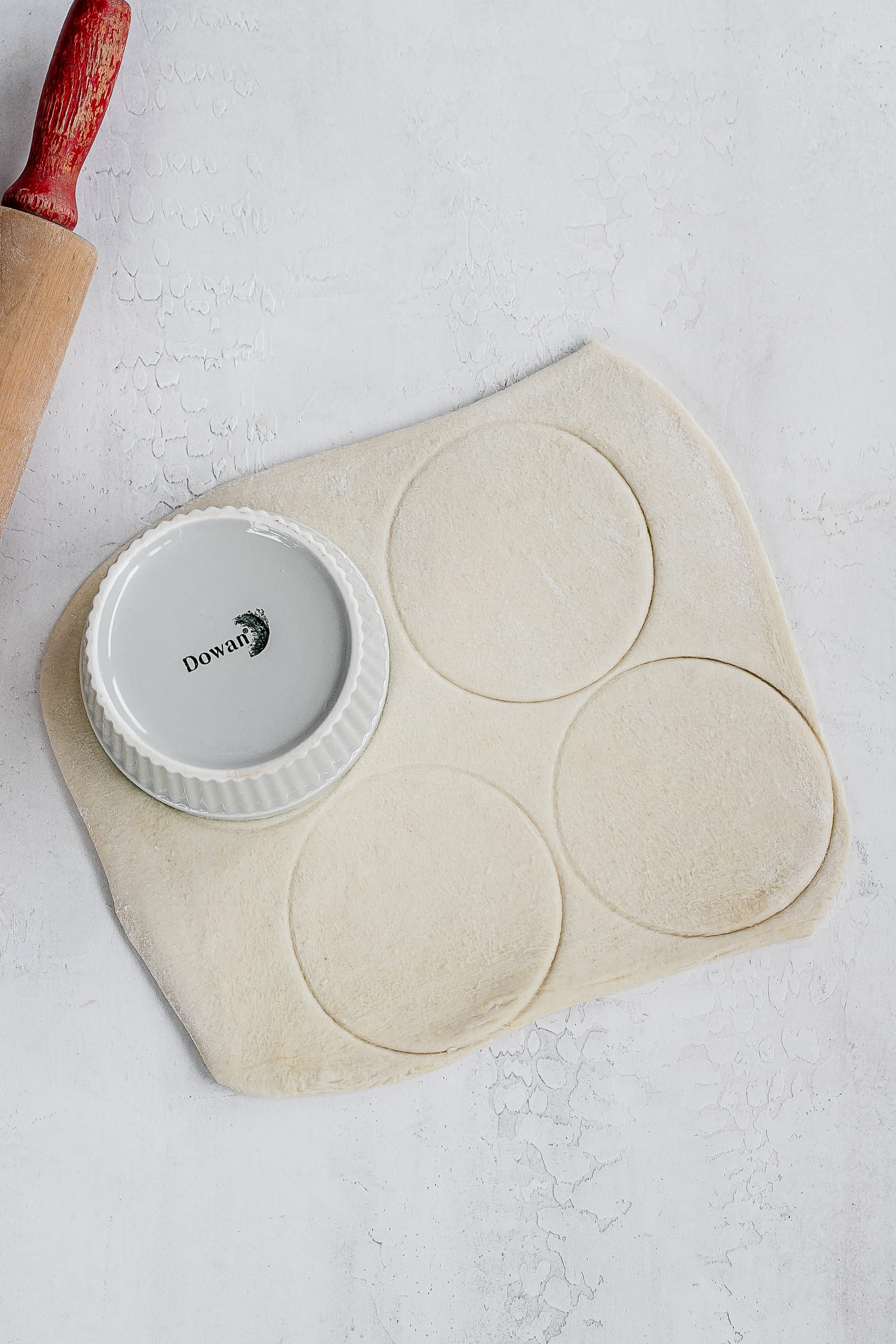 puff pastry rolled out with ramekins.