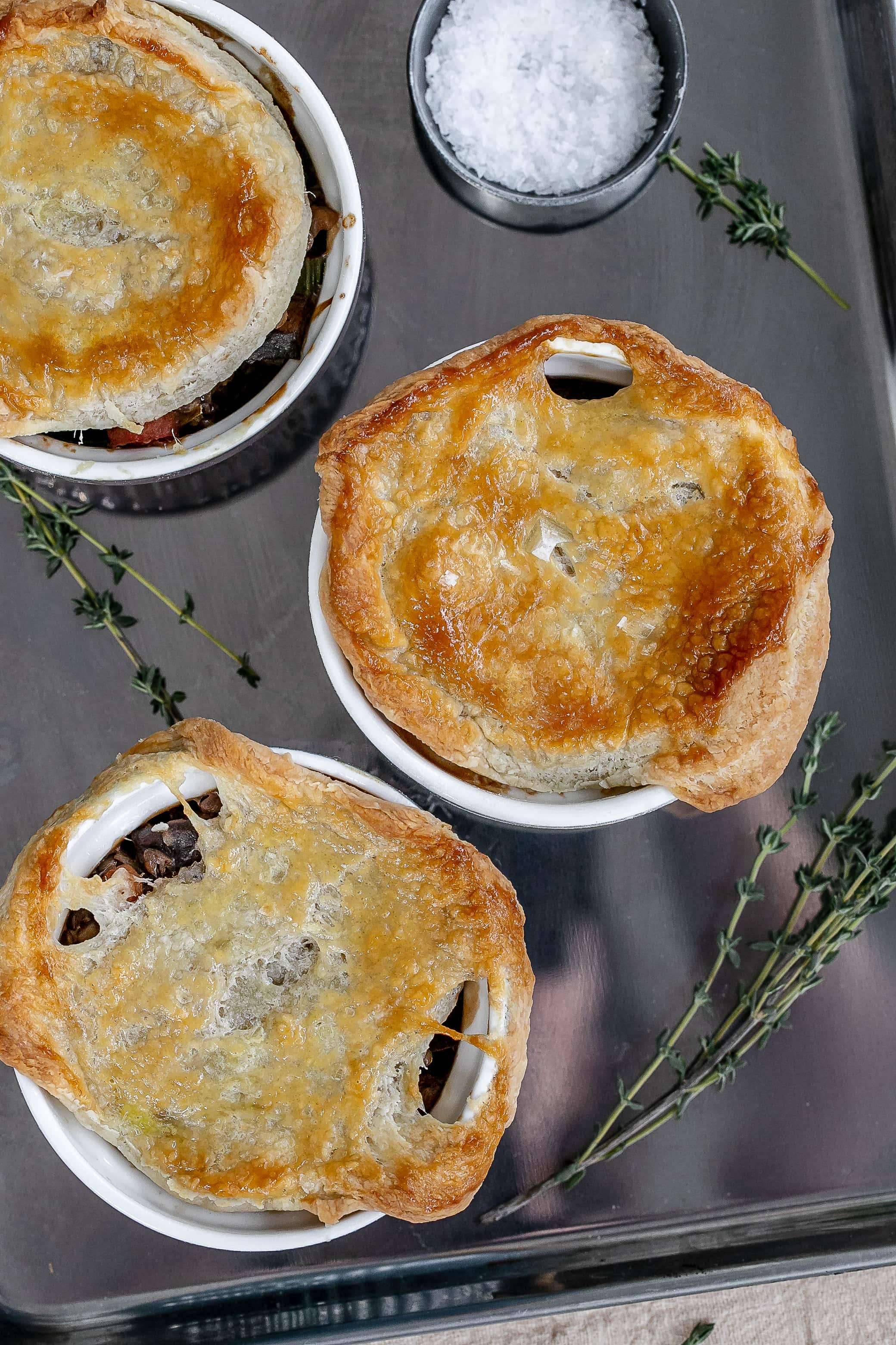 mushroom pot pies in ramekins on baking sheet.