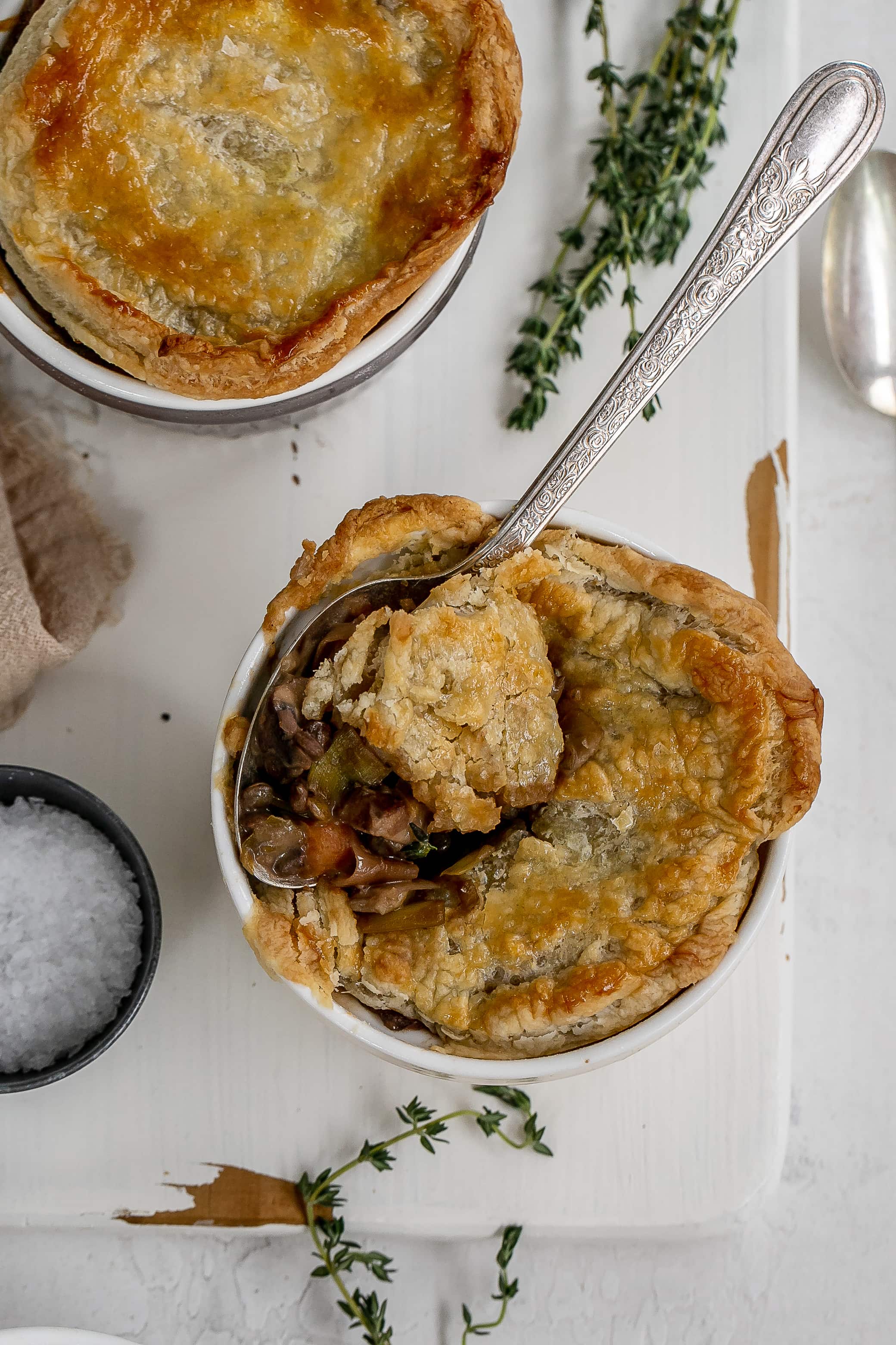 mushroom and lentil pot pies in ramekins on cutting board.