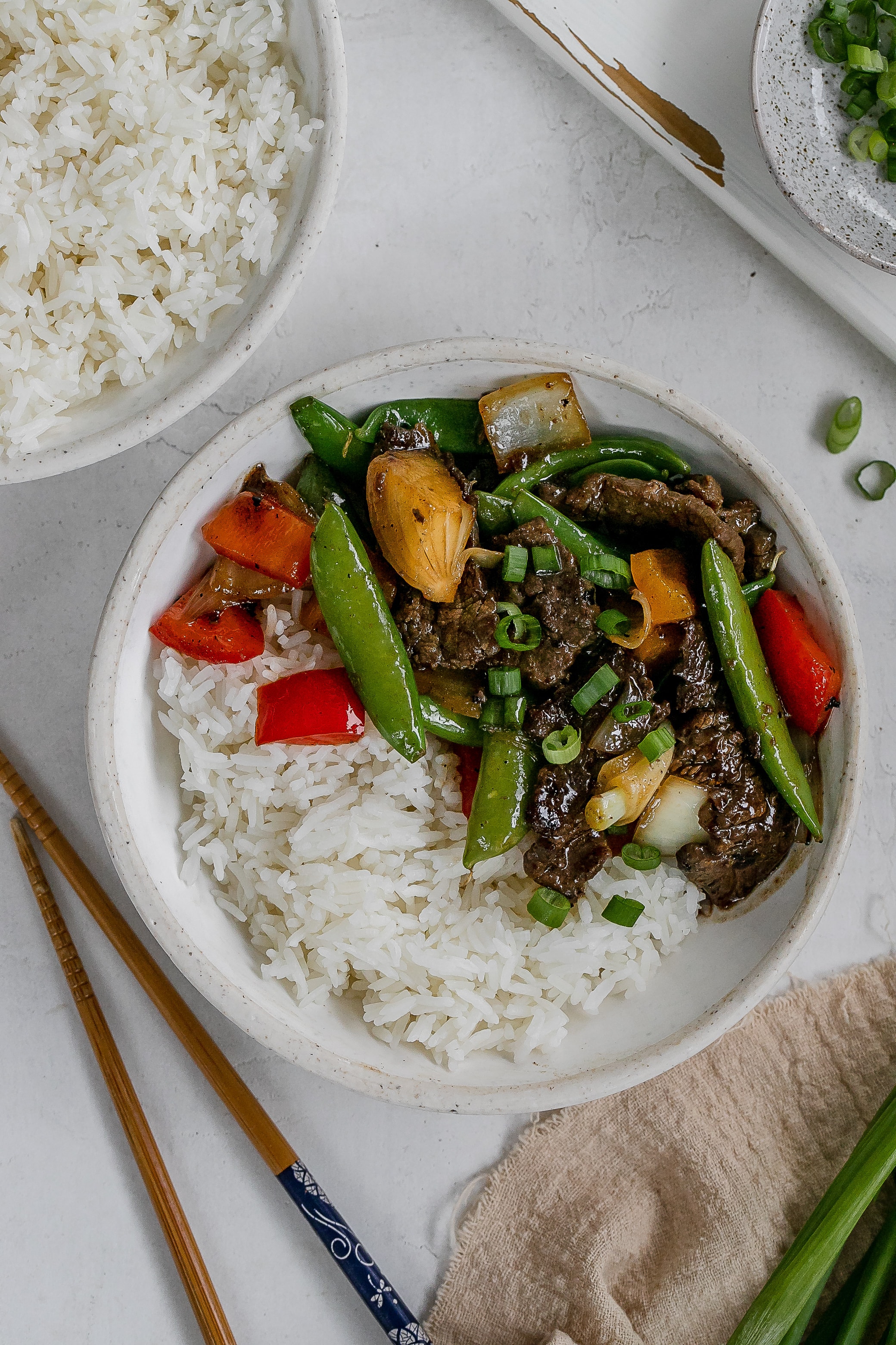 flank steak stir fry in a bowl with rice.