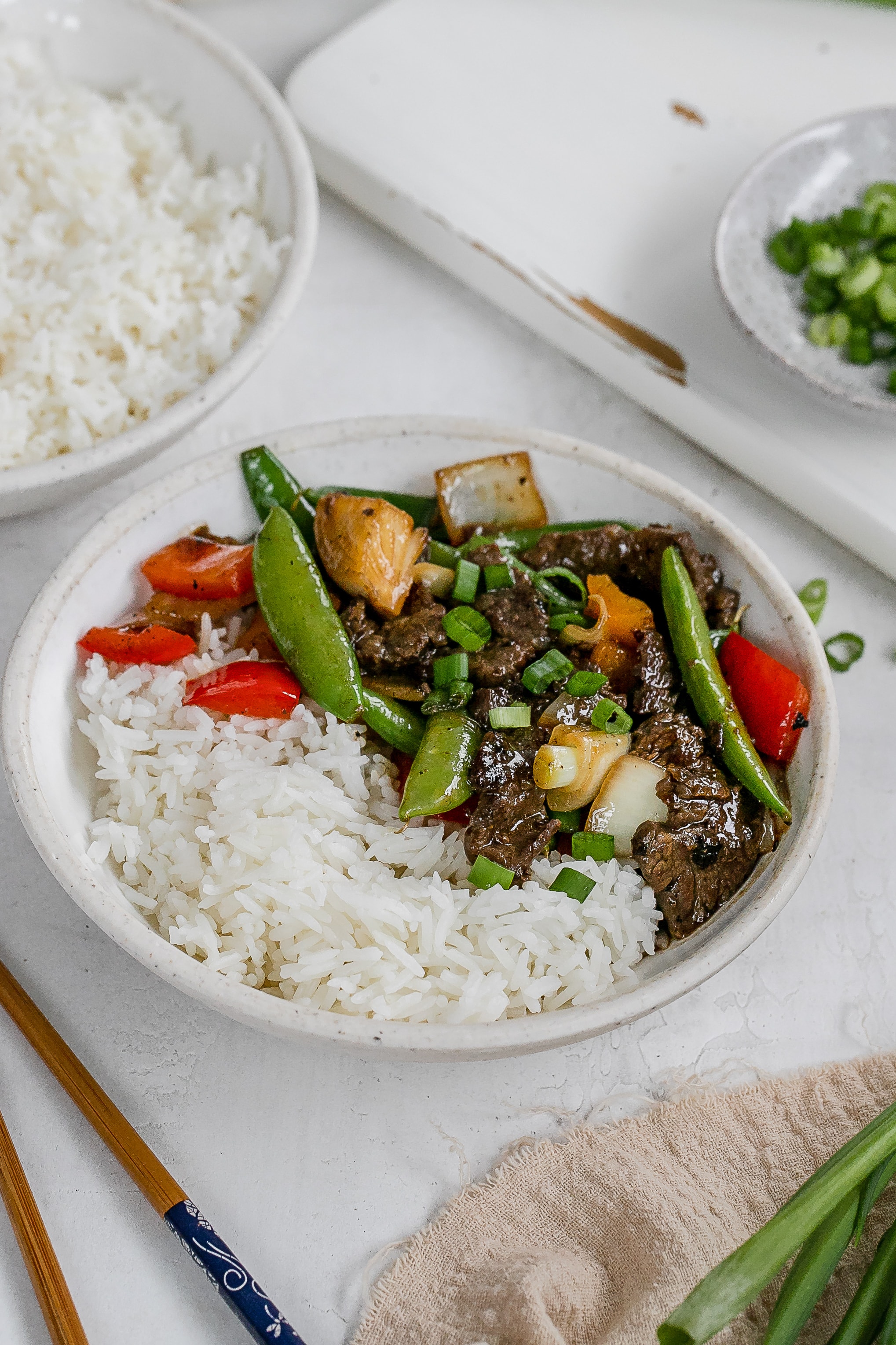 flank steak stir fry in bowl with rice.
