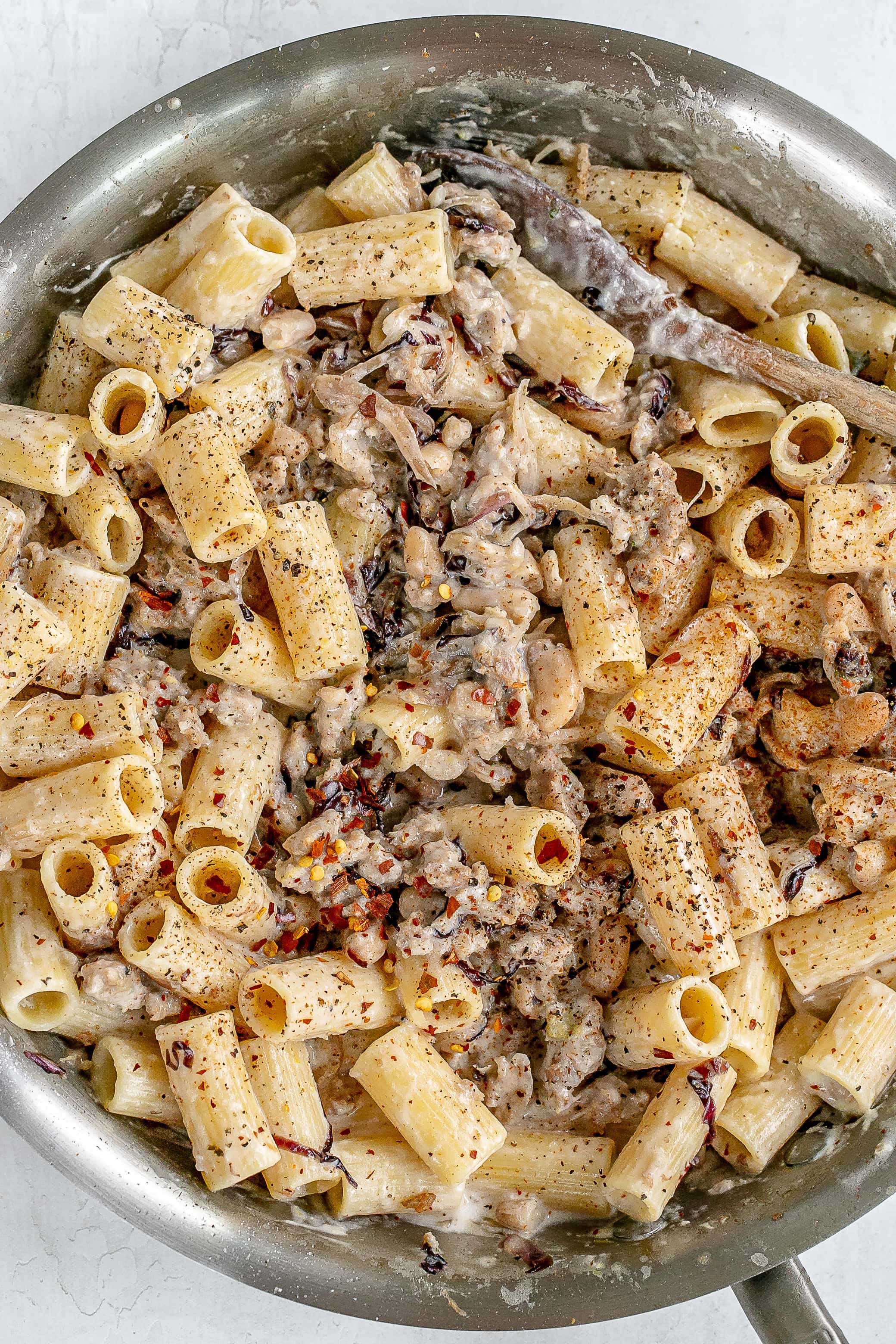 pasta with sausage and ricotta cheese in skillet.