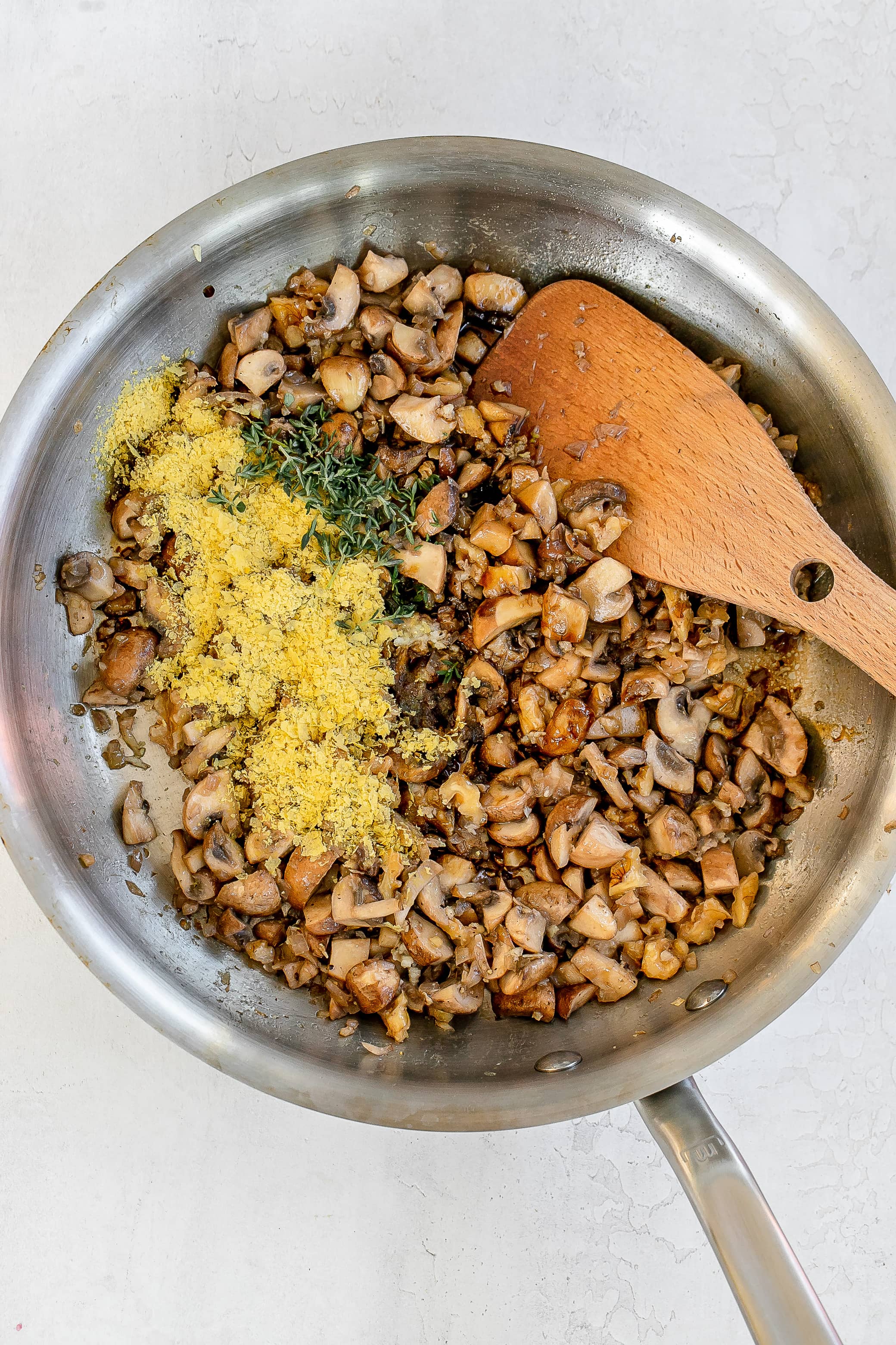 mushroom mixture in skillet with add in ingredients.