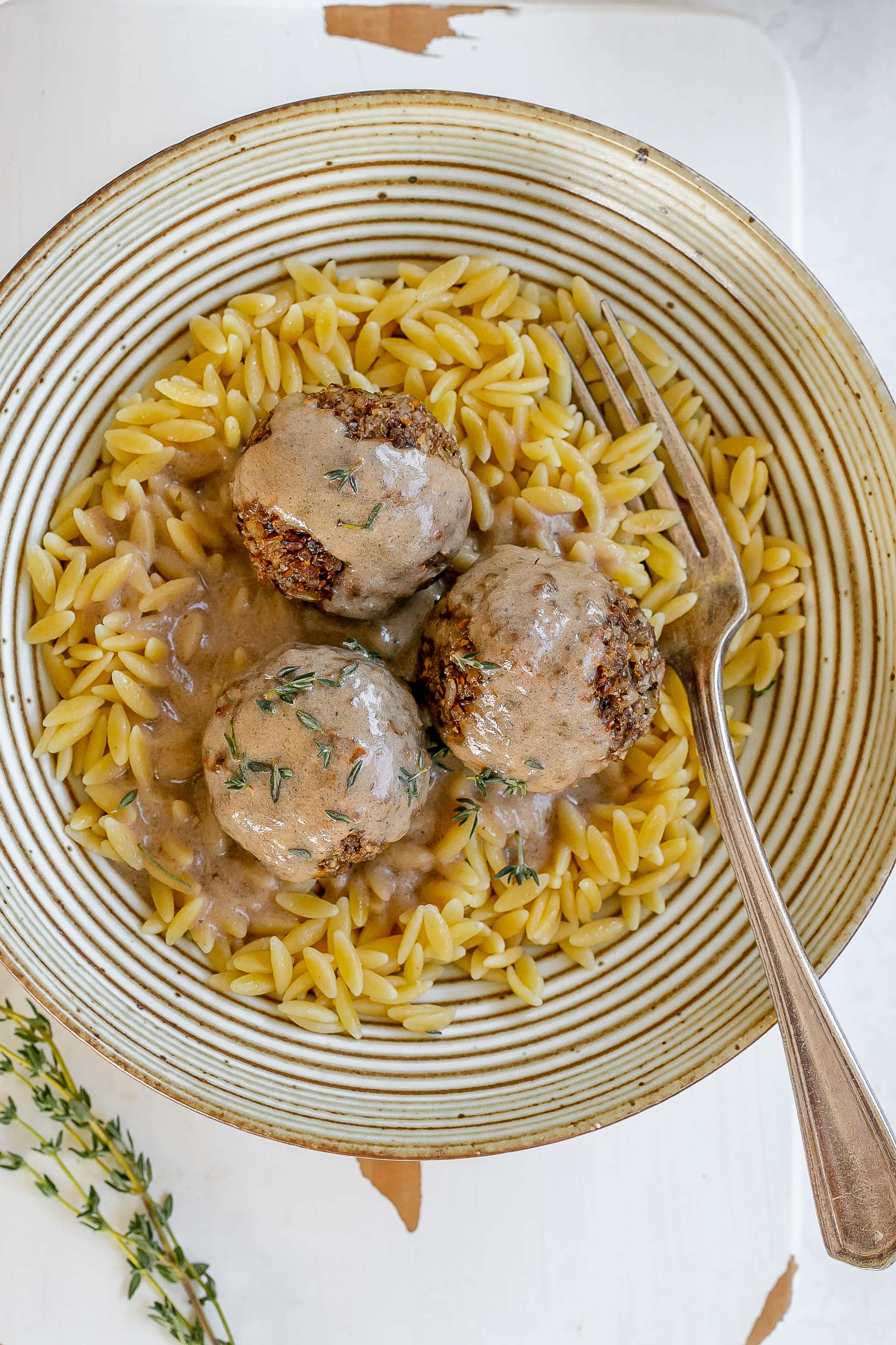 mushroom meatballs in a bowl with orzo and sauce.