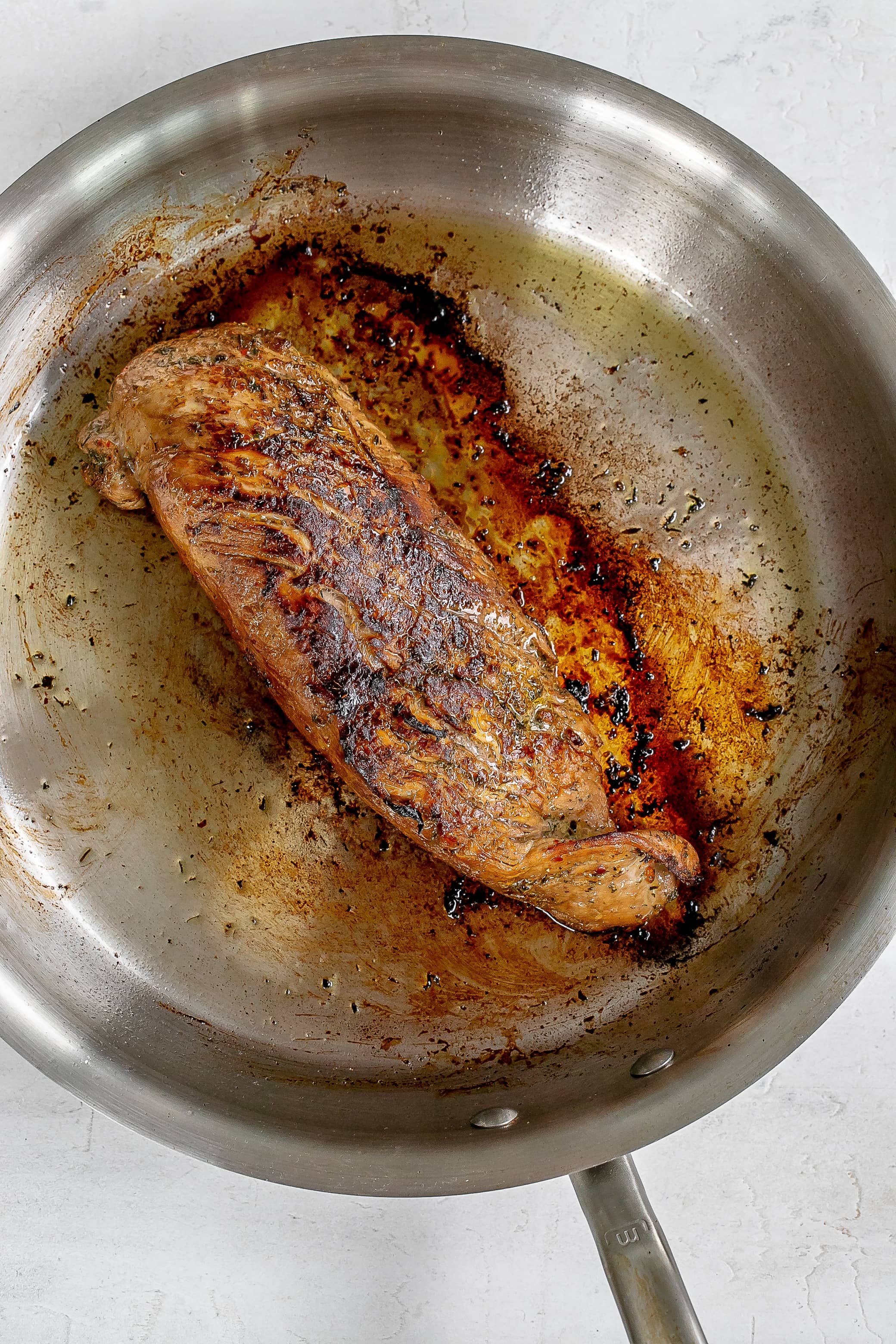 cooked pork tenderloin in skillet.