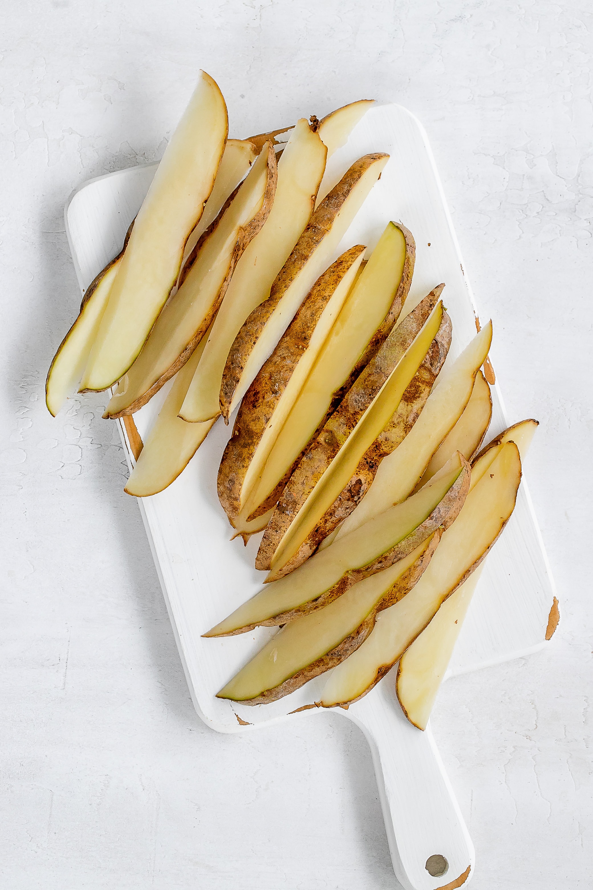 potato wedges sitting on cutting board.