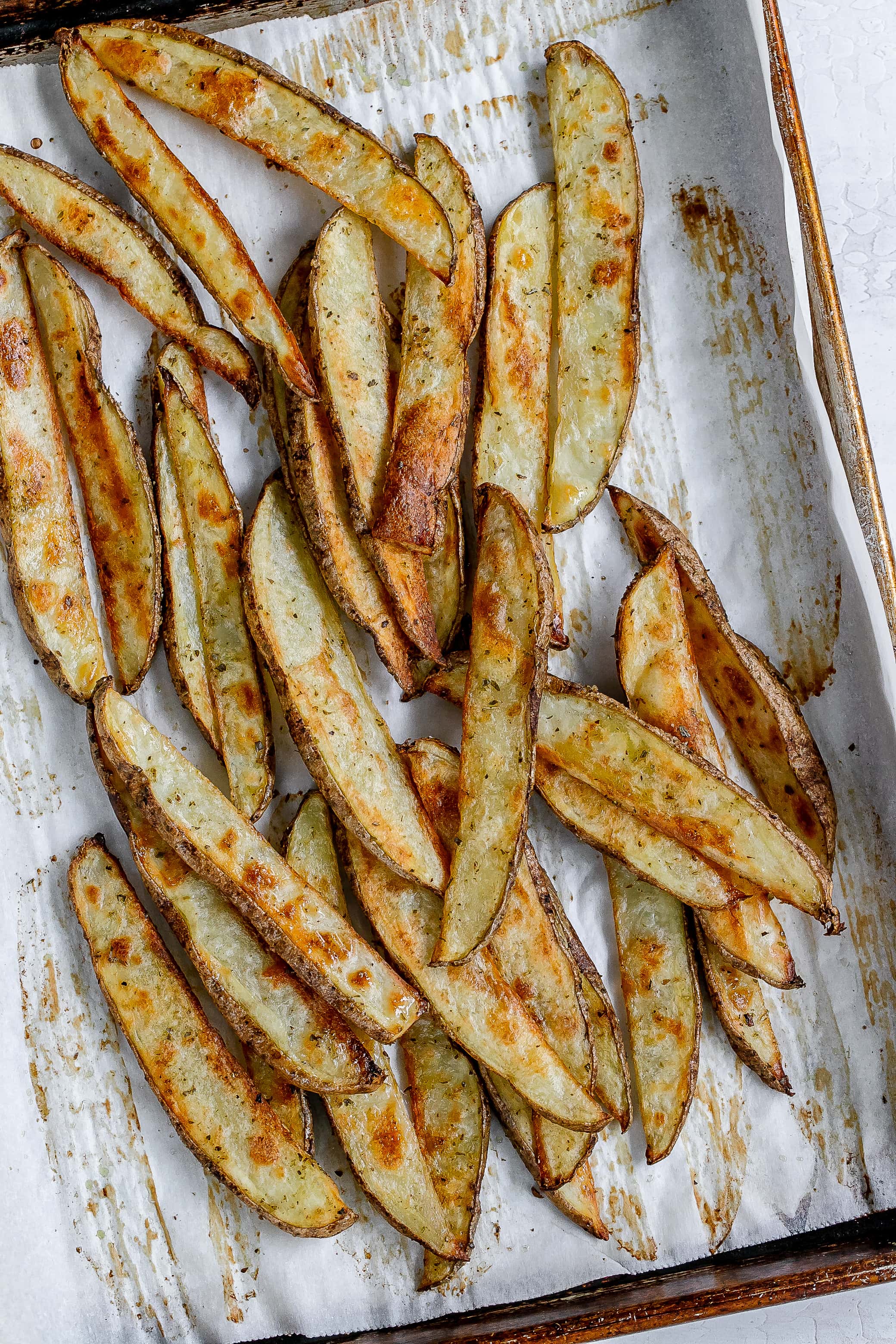potato wedges baked on baking sheet with parchment paper.