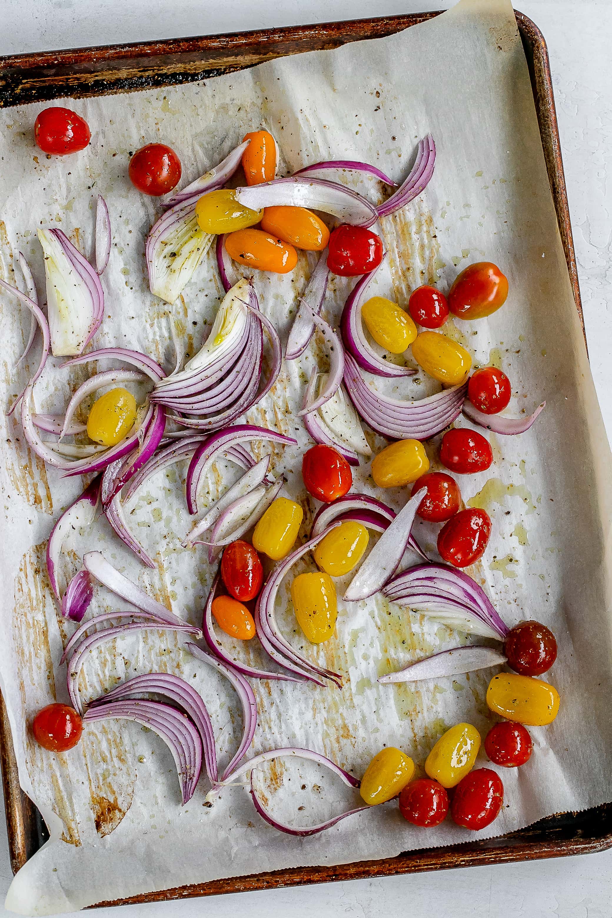 tomatoes and onion on baking sheet.